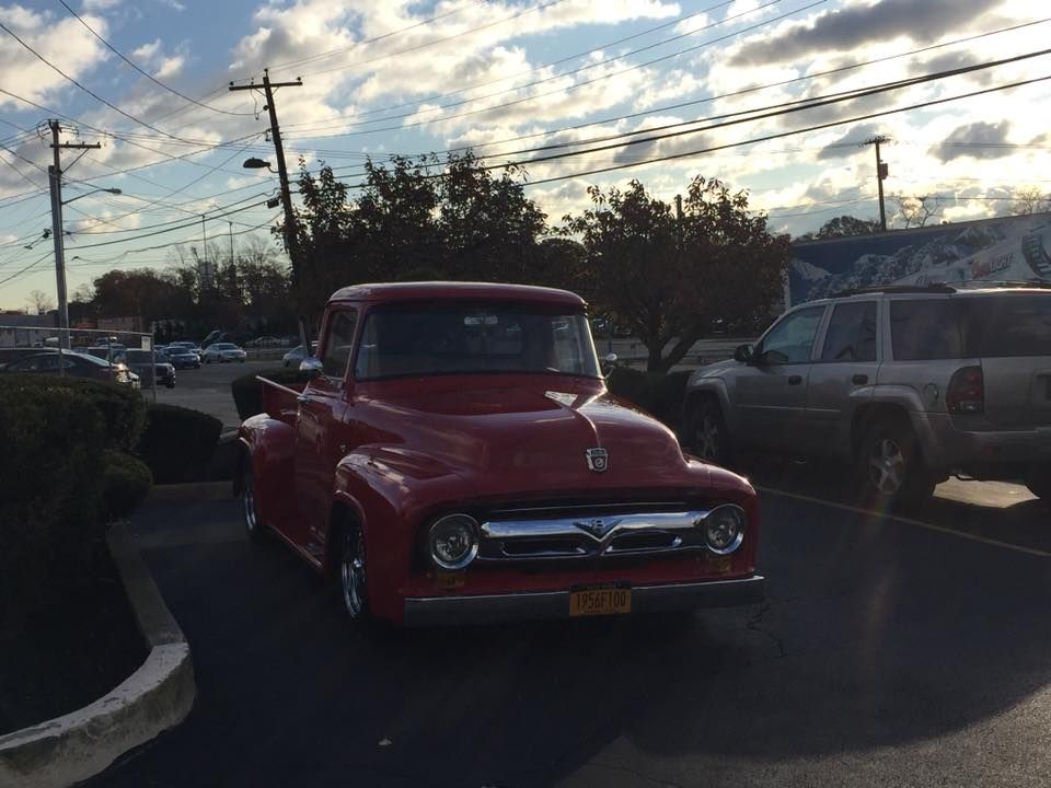 a red ford truck is parked in a parking lot