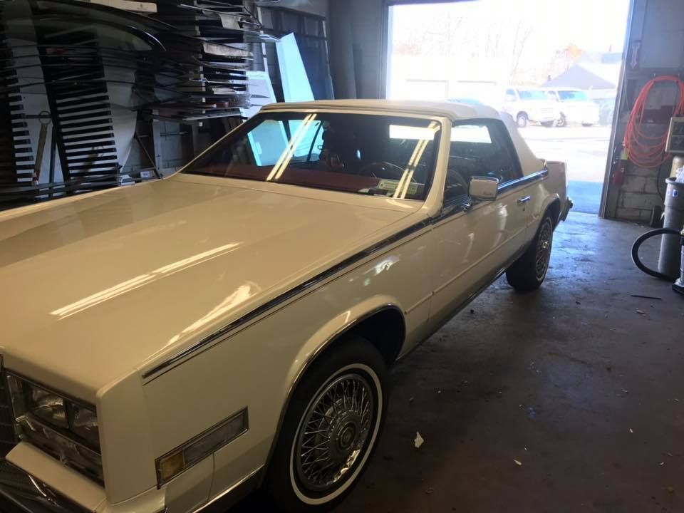 a white car is parked in a garage next to a ladder