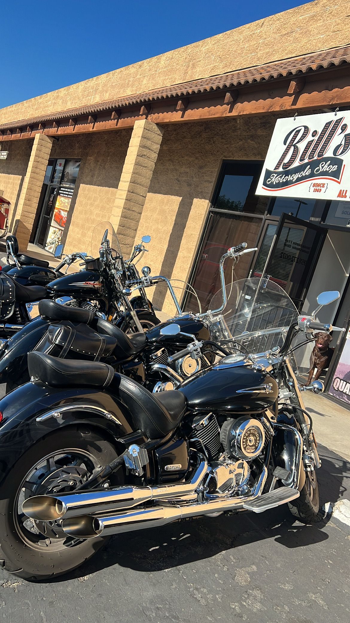 Motorcycles parked outside a building with a sign that reads 
