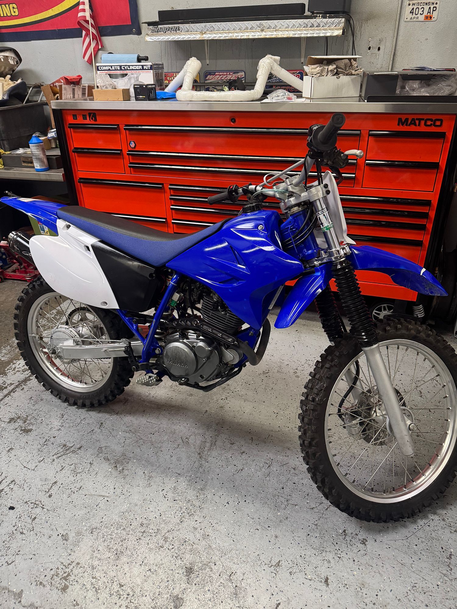 Blue Yamaha dirt bike in a garage.
