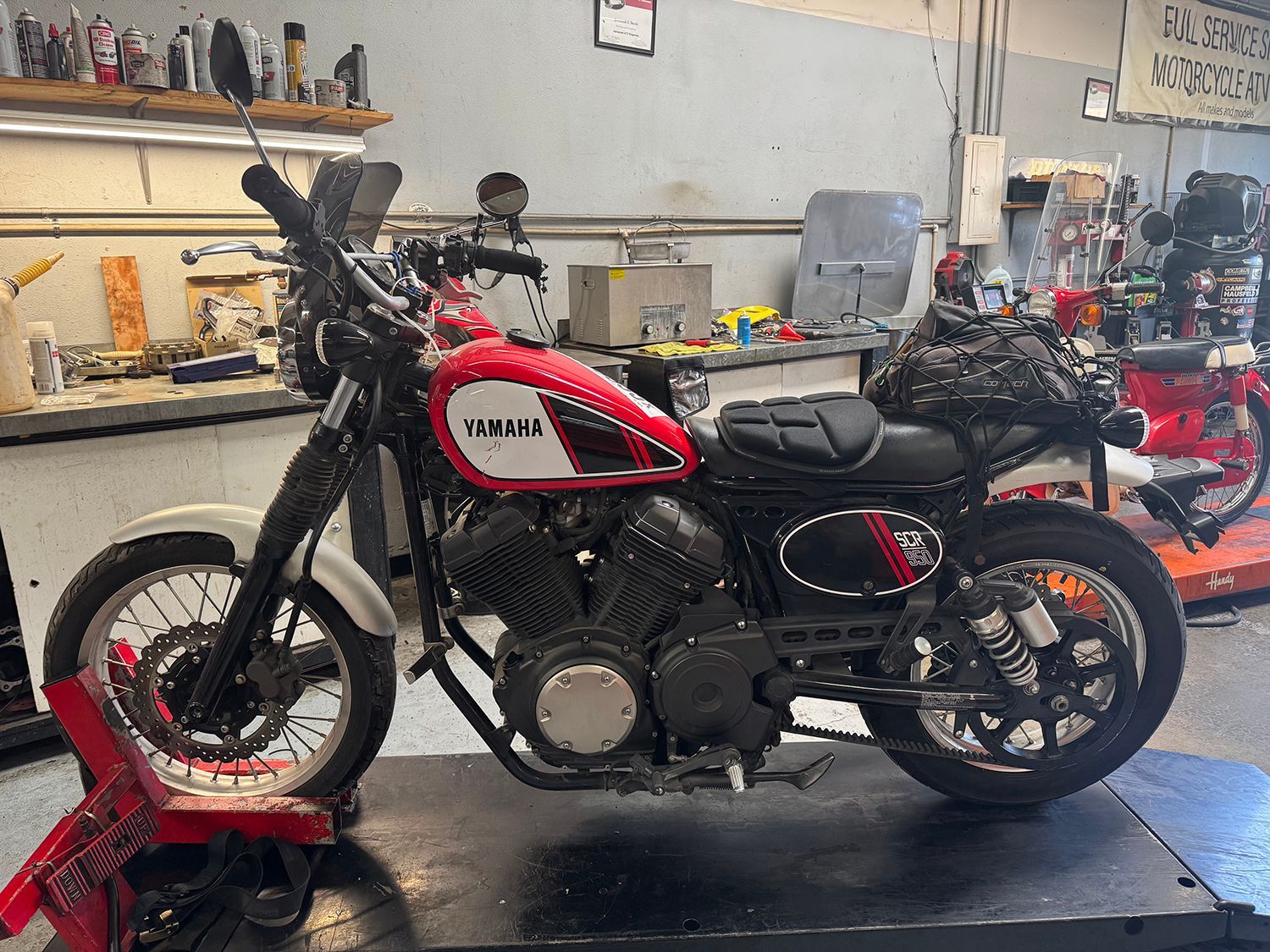 Red and white Yamaha motorcycle in a garage.