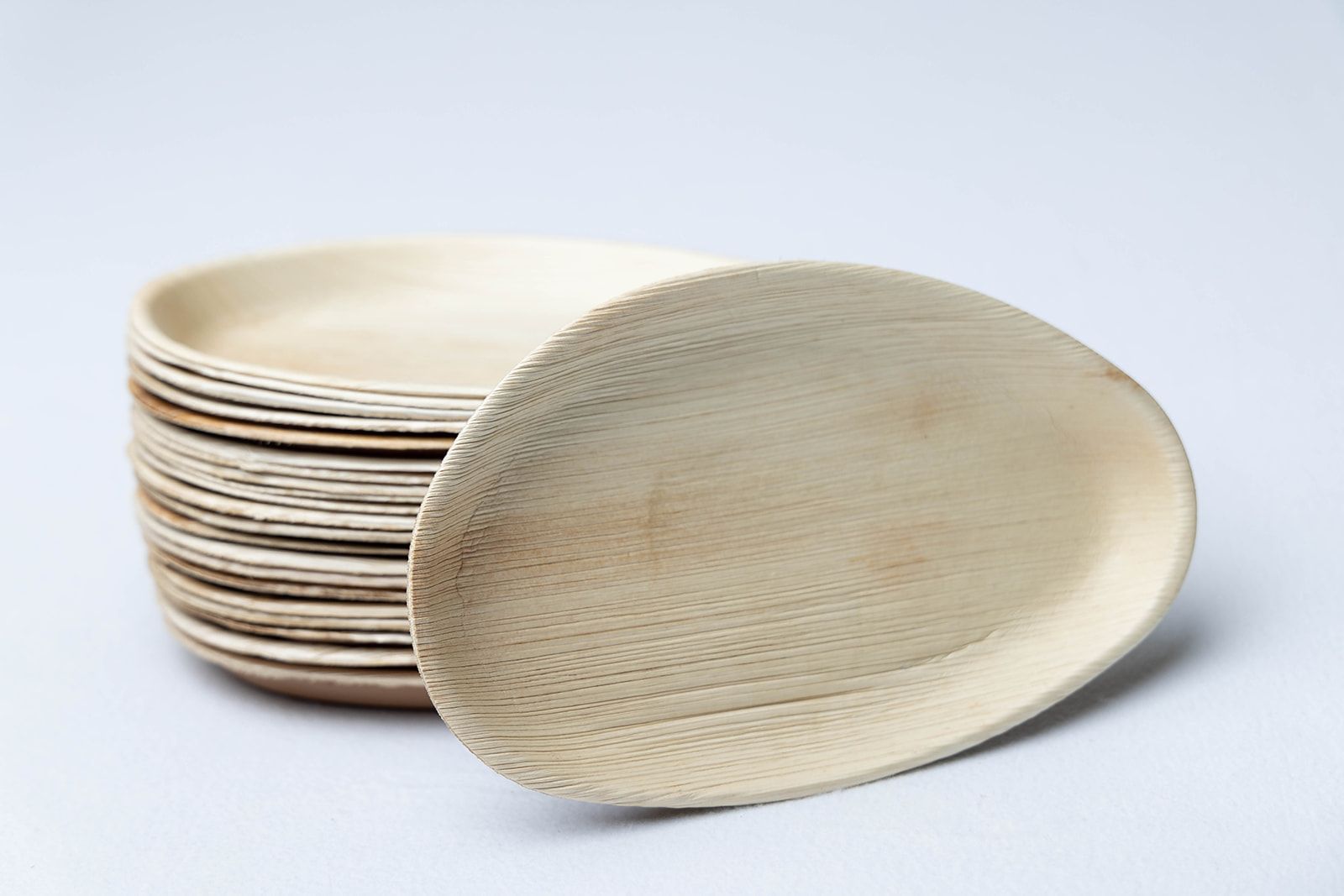 A stack of wooden plates on a white surface