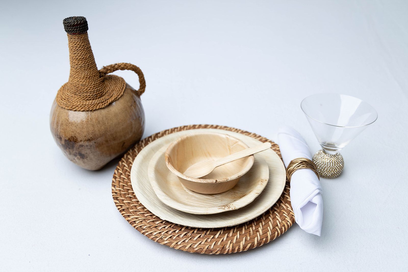 A table setting with plates a bowl a bottle and a glass