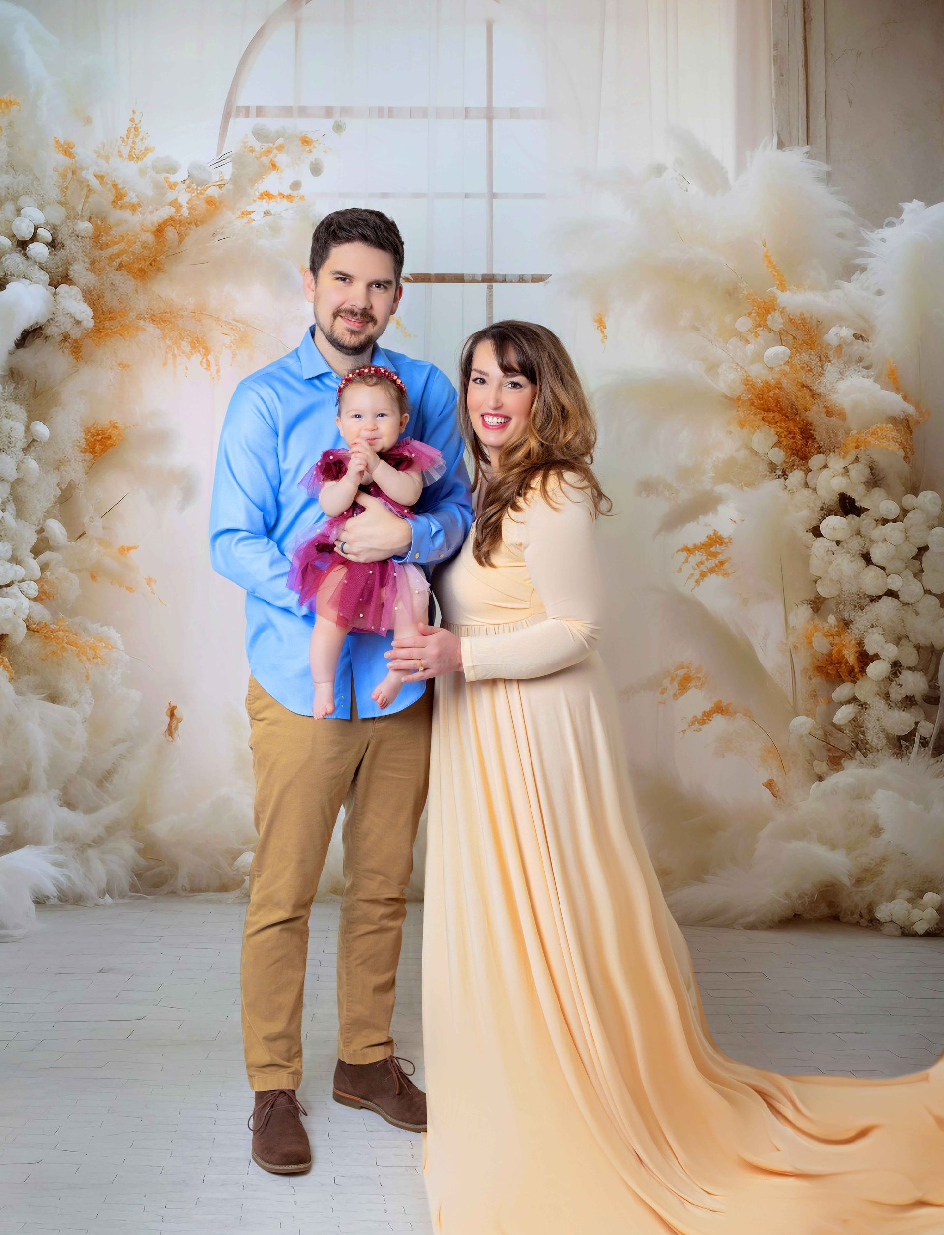 A man and a woman are standing next to each other holding a baby.