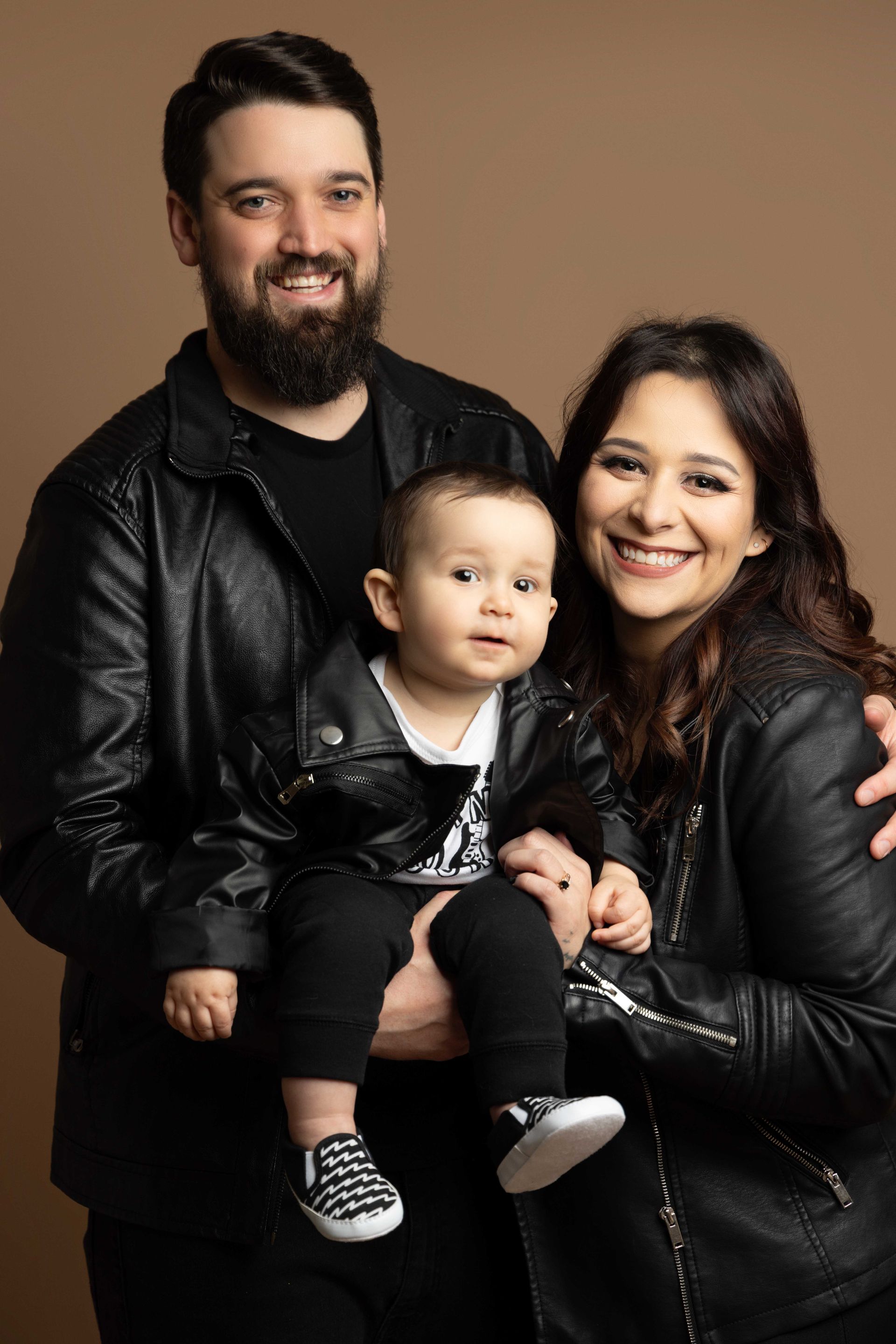 A man and woman are holding a baby in their arms.