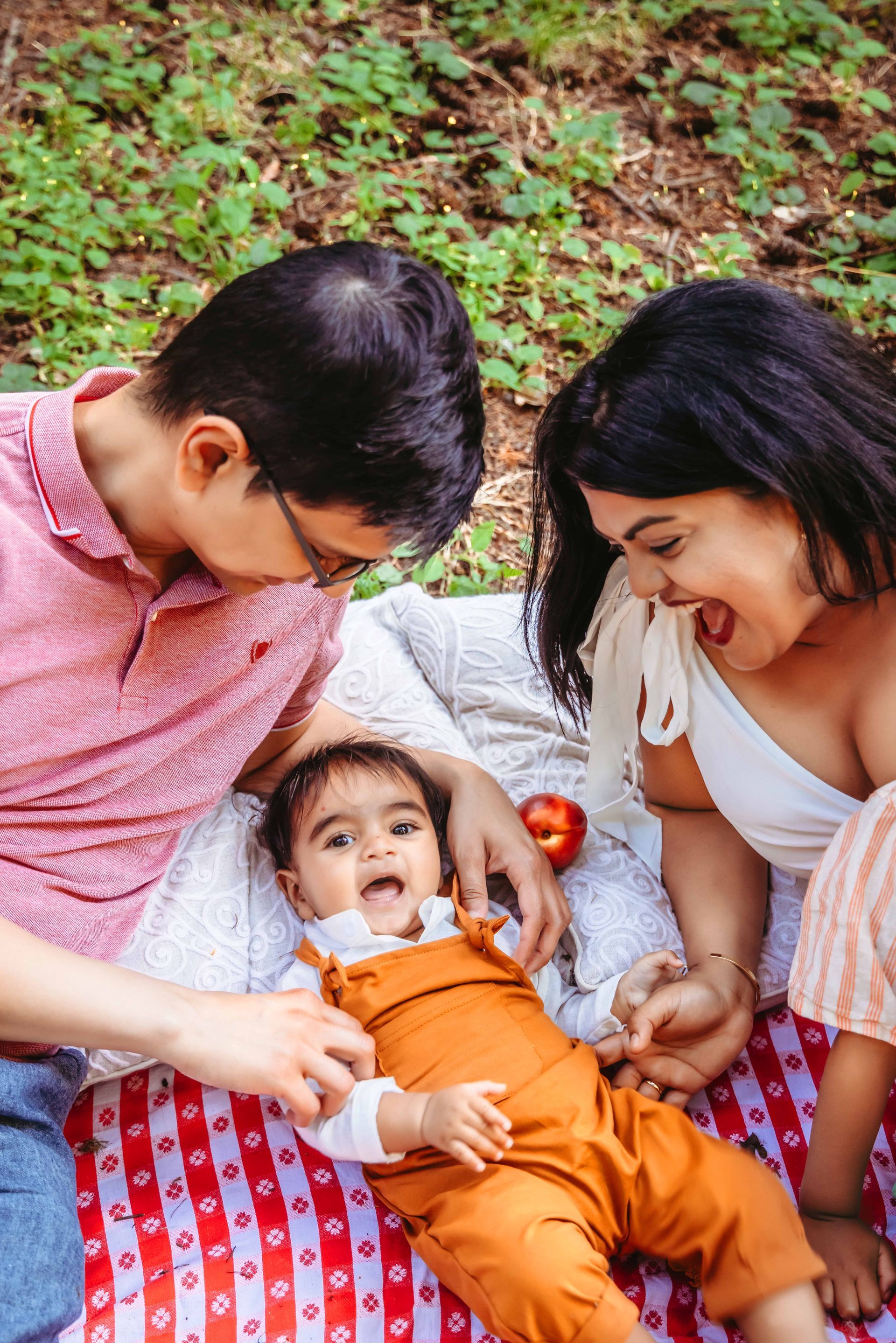 A family is posing for a picture in the woods.
