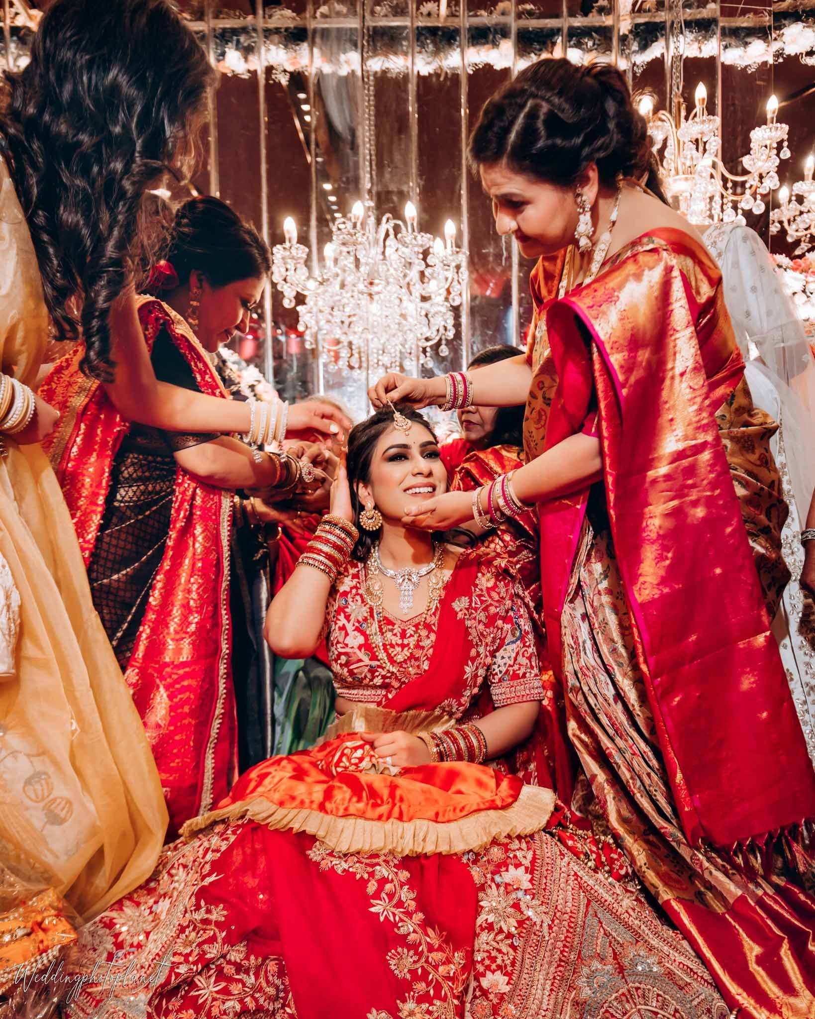 A group of women are helping a bride get ready for her wedding.