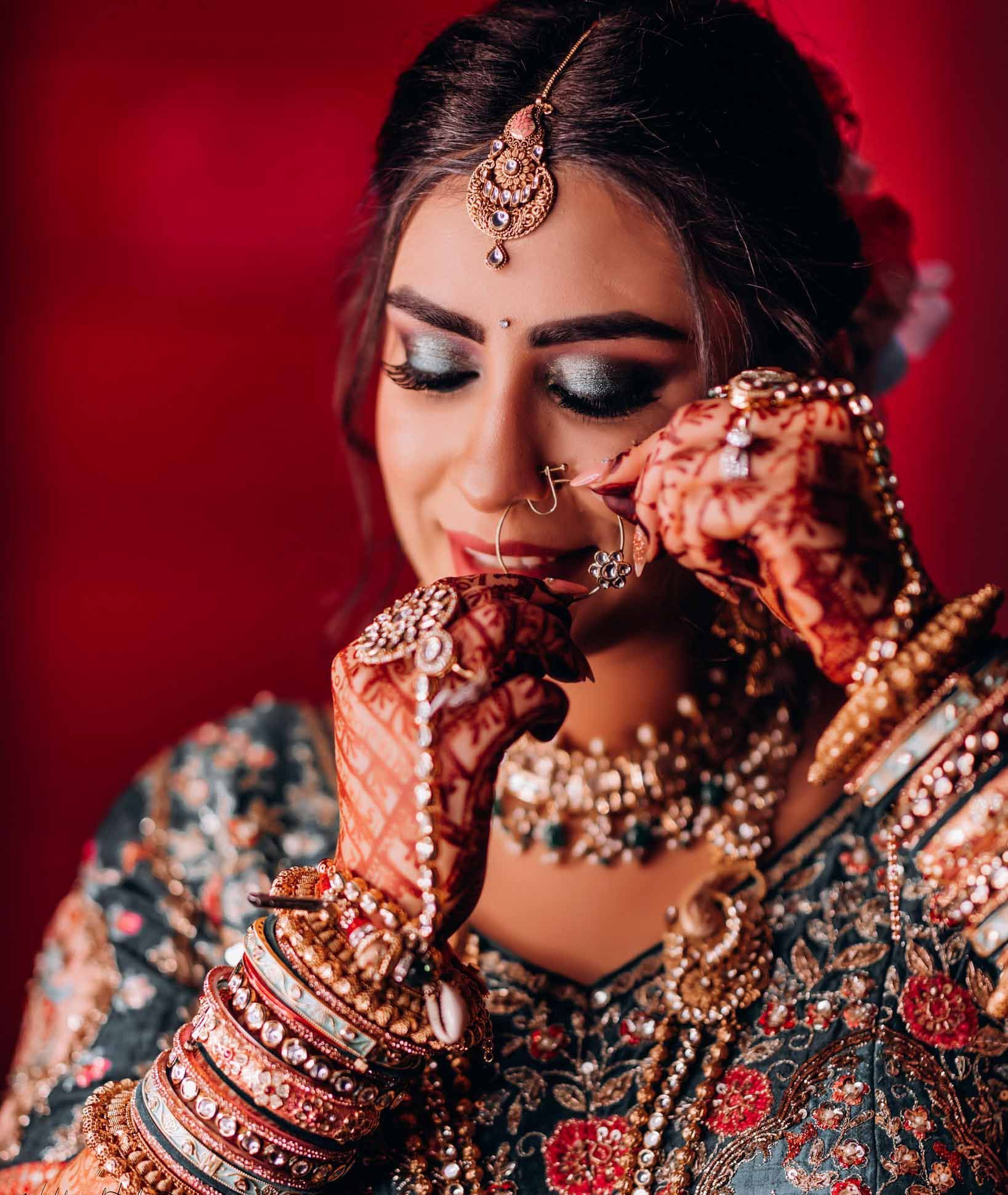 A close up of a woman wearing a traditional indian wedding dress and jewelry.