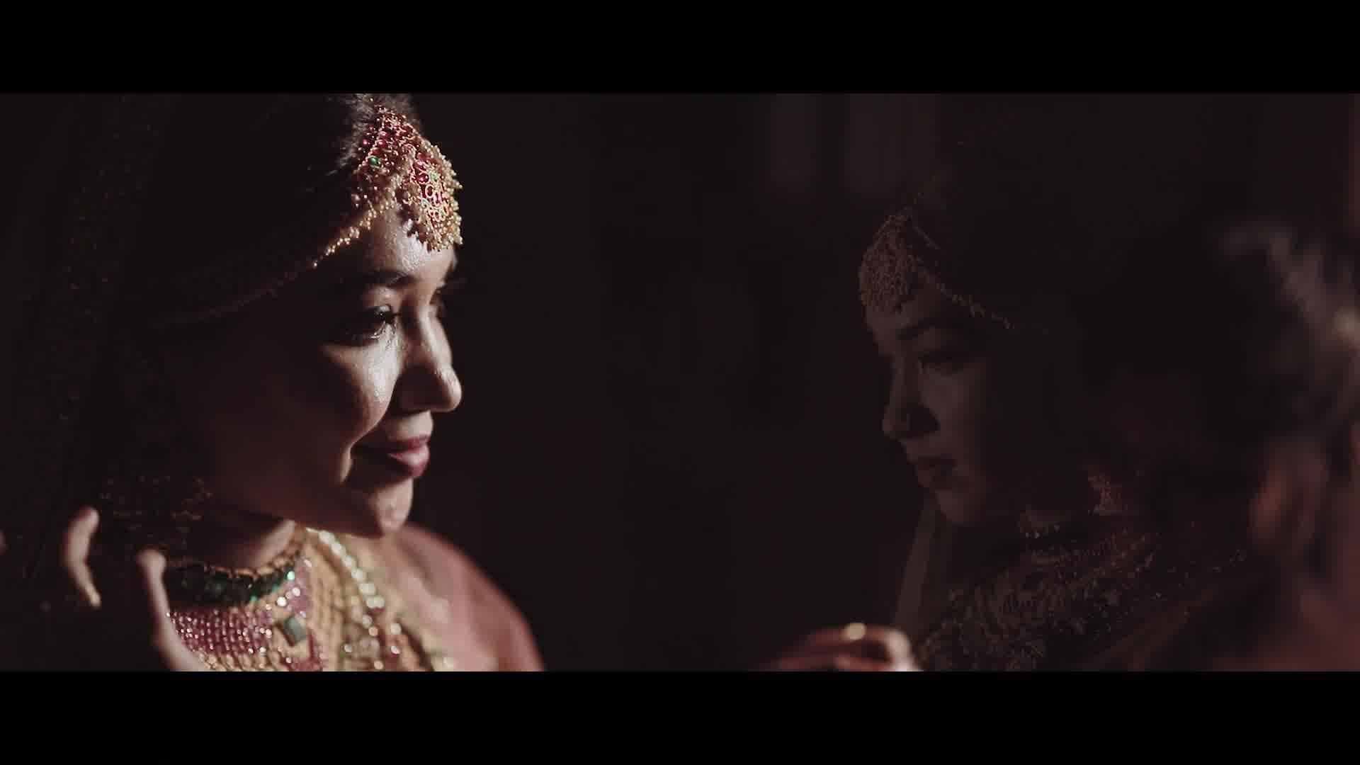 A bride and groom are looking at each other in a dark room.