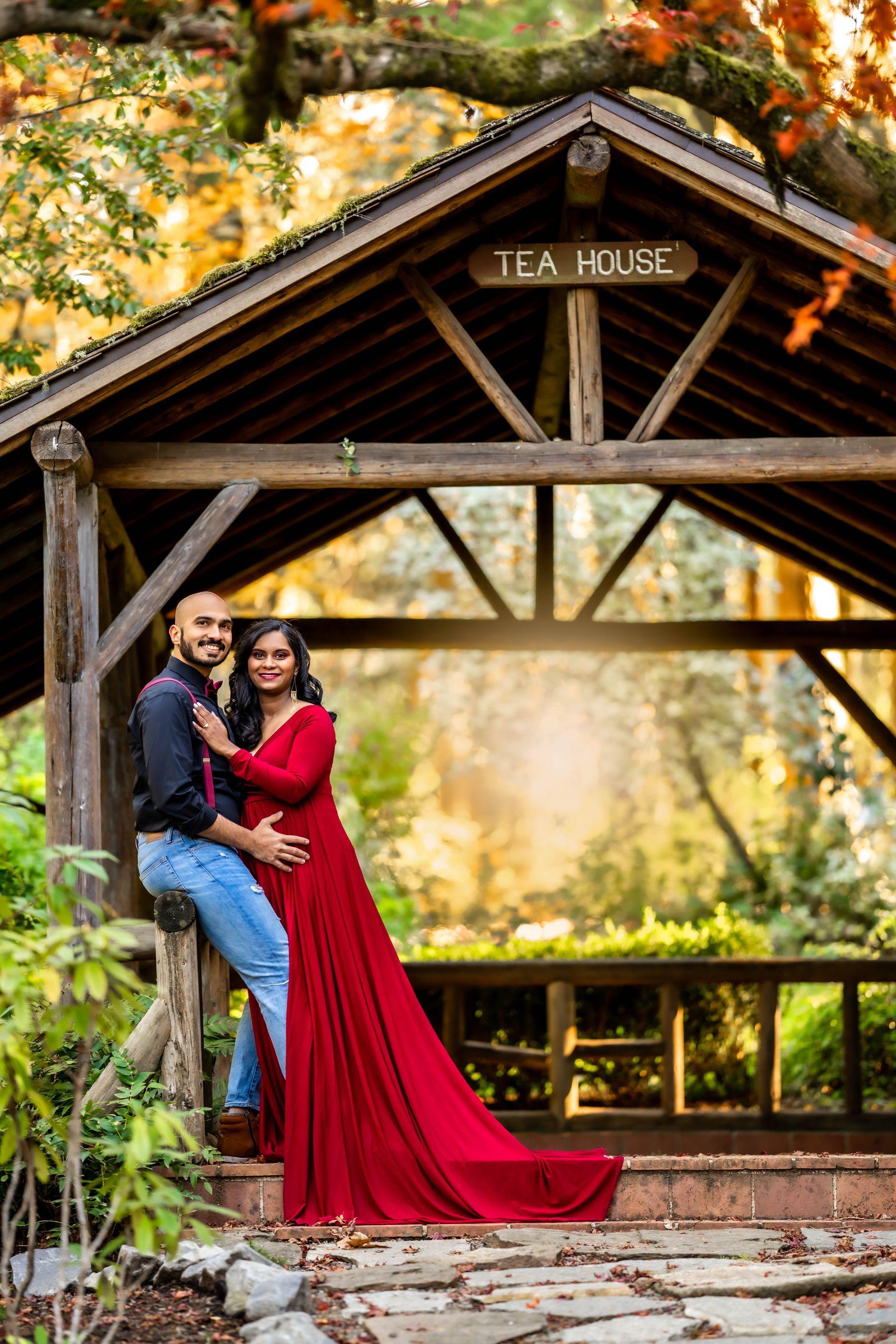 A man and a woman are posing for a picture in front of a tea house.
