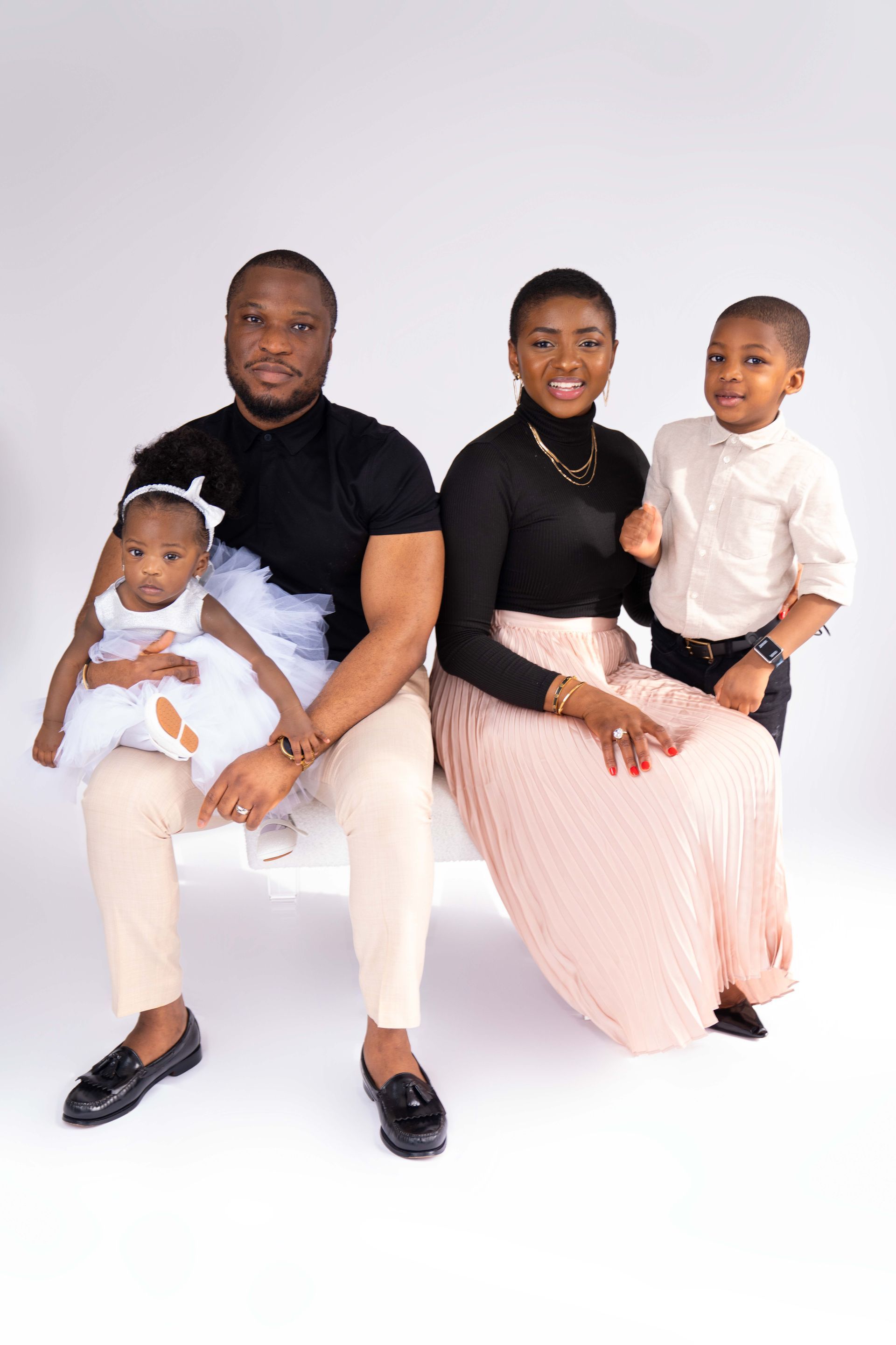 A family is posing for a picture while sitting on a bench.