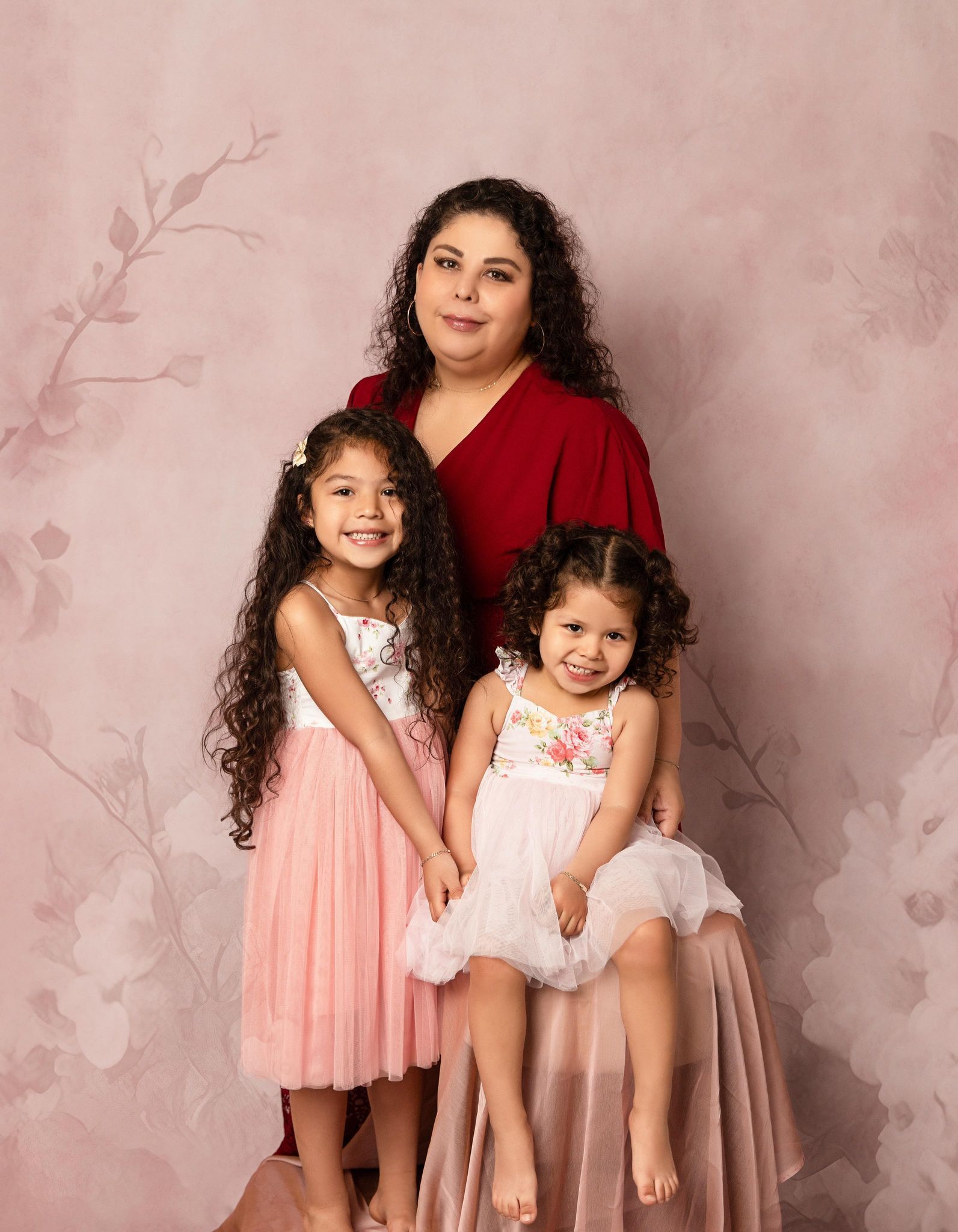 A woman and two little girls are posing for a picture.