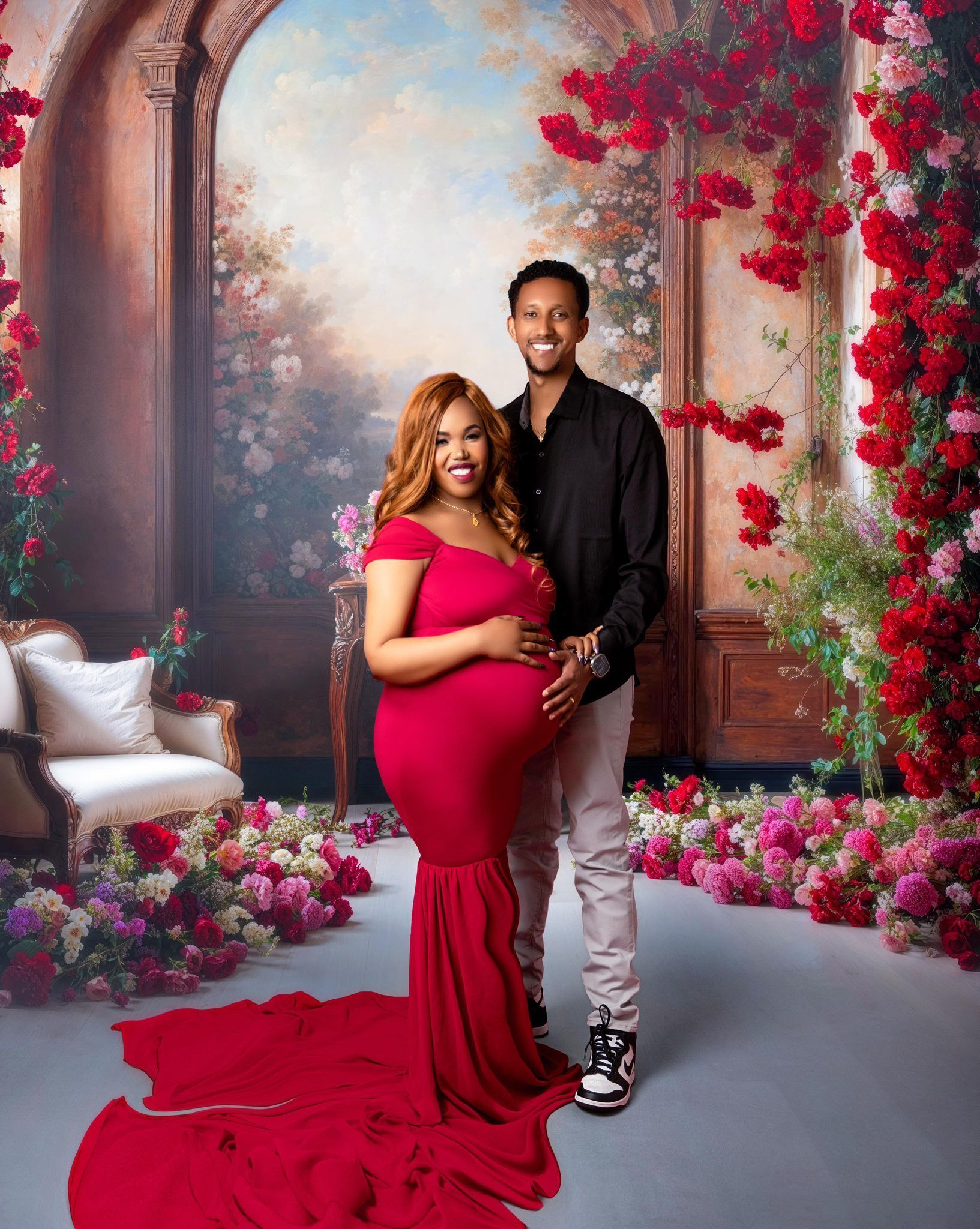 A pregnant woman in a red dress is standing next to a man in a black shirt.