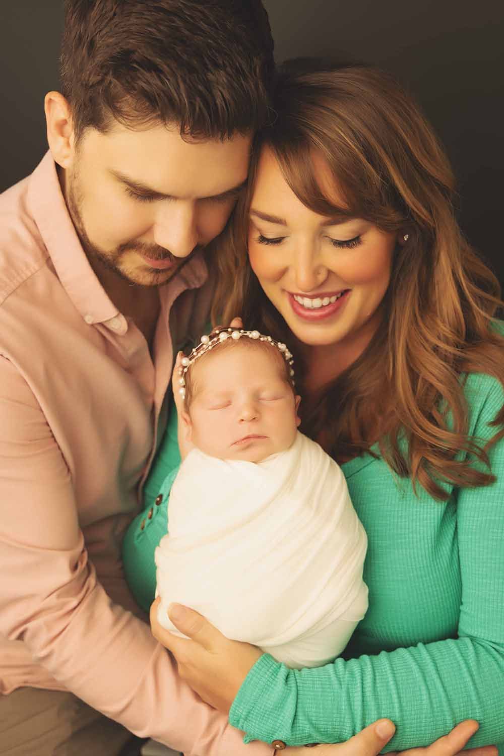 Parents proudly carrying their newborn baby