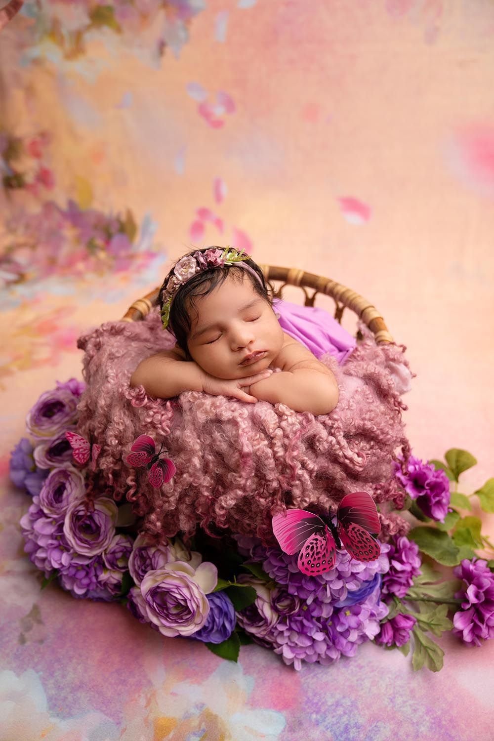 Infant in a baby basket with floral design