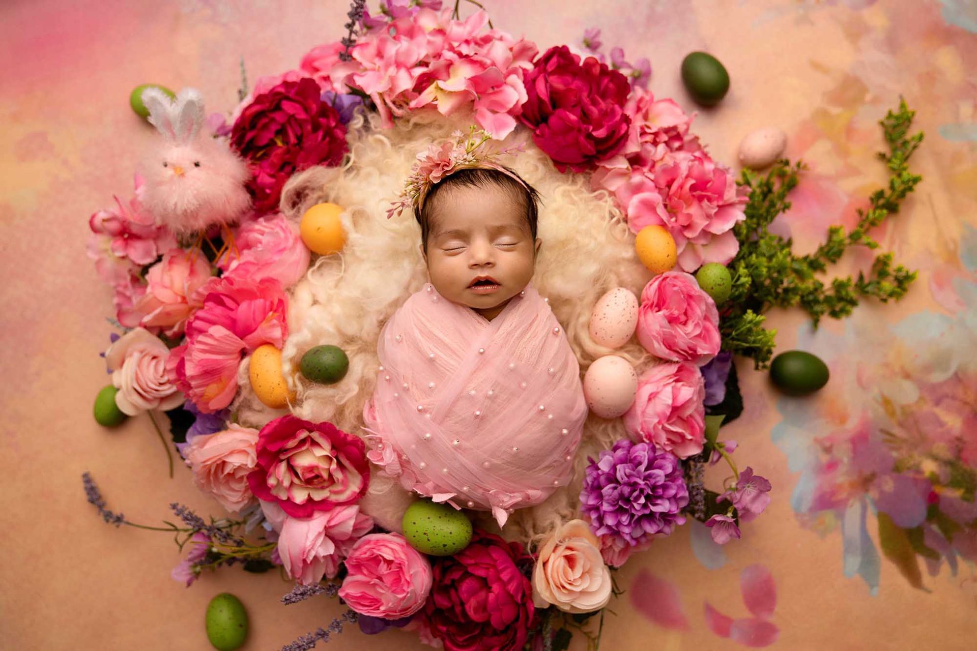 Sleeping baby surrounded by a beautiful arrangement of flowers