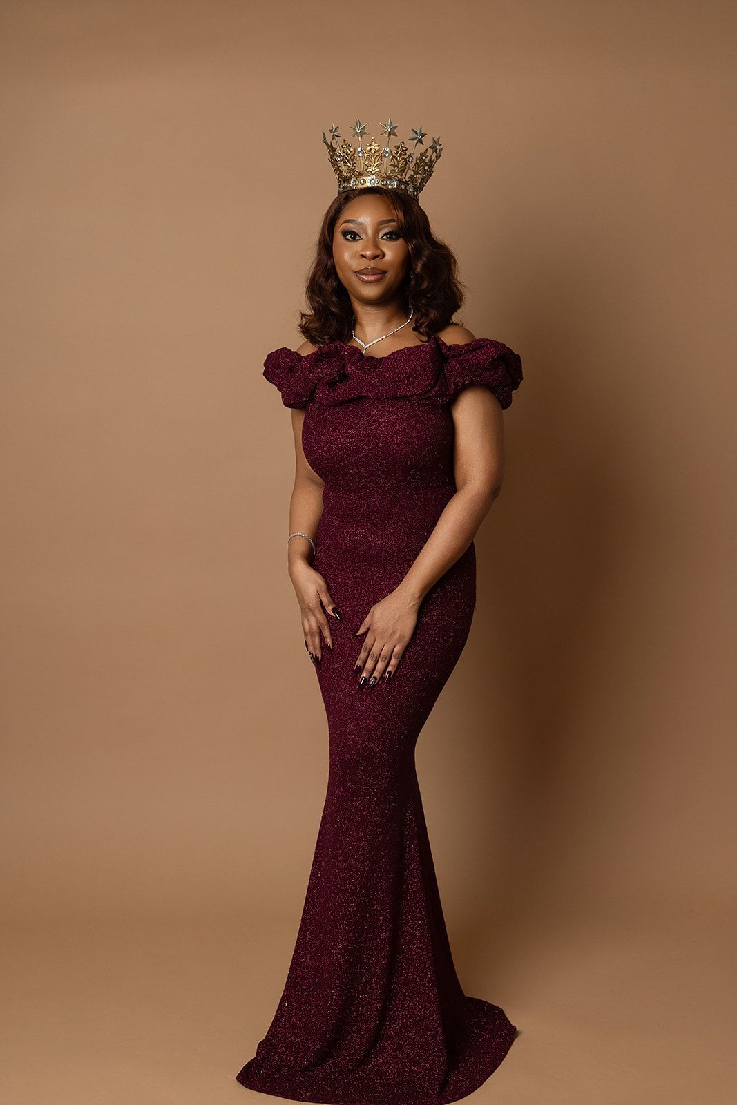 A woman in a purple dress is wearing a crown.