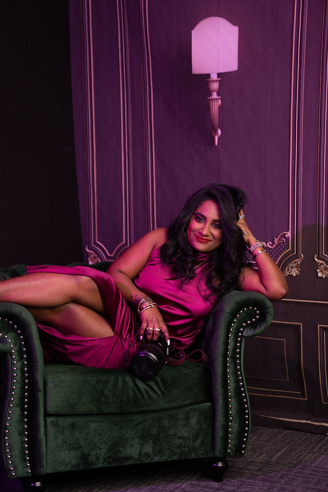 A woman in a purple dress is sitting on a green couch