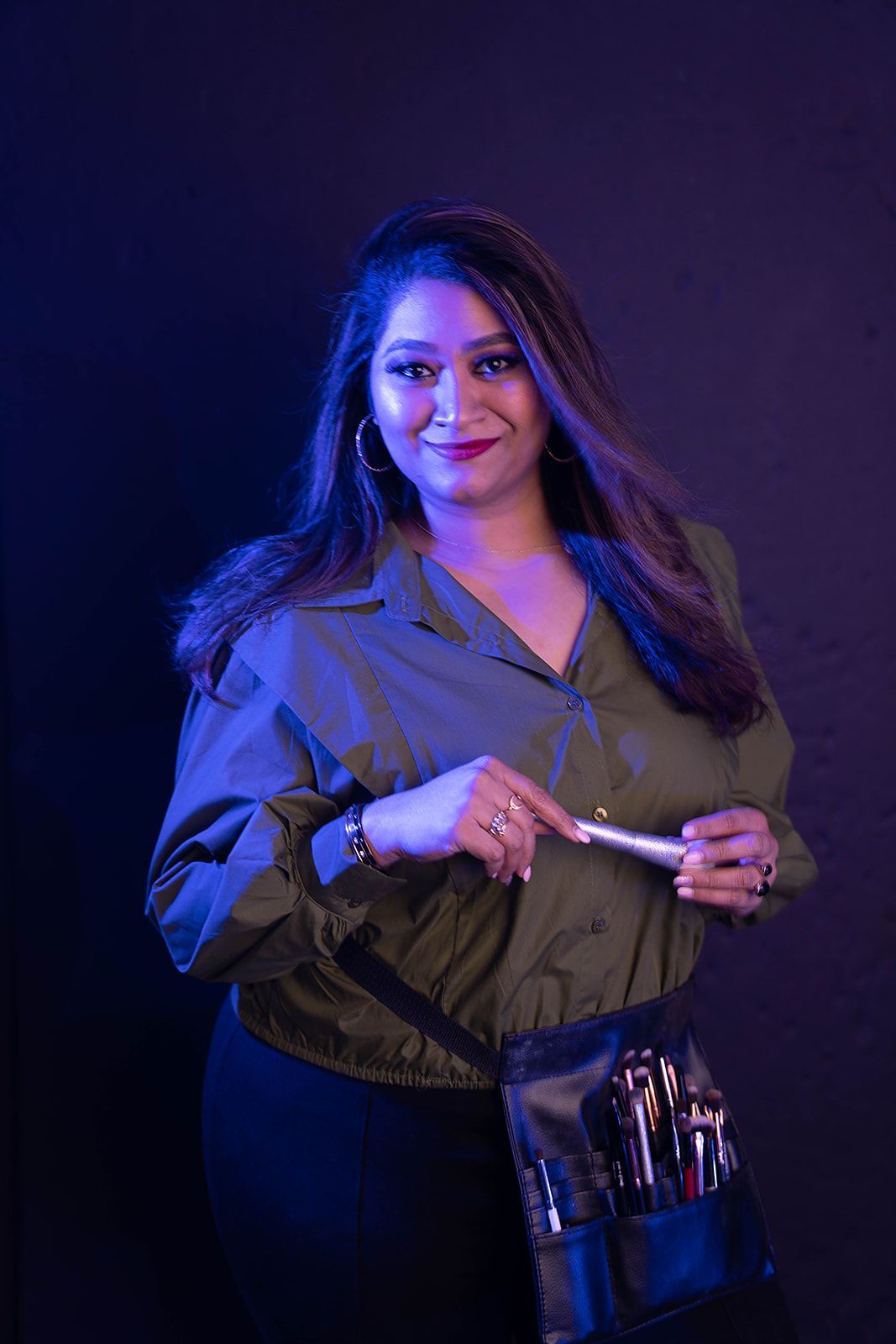 A woman is holding a makeup bag and a brush
