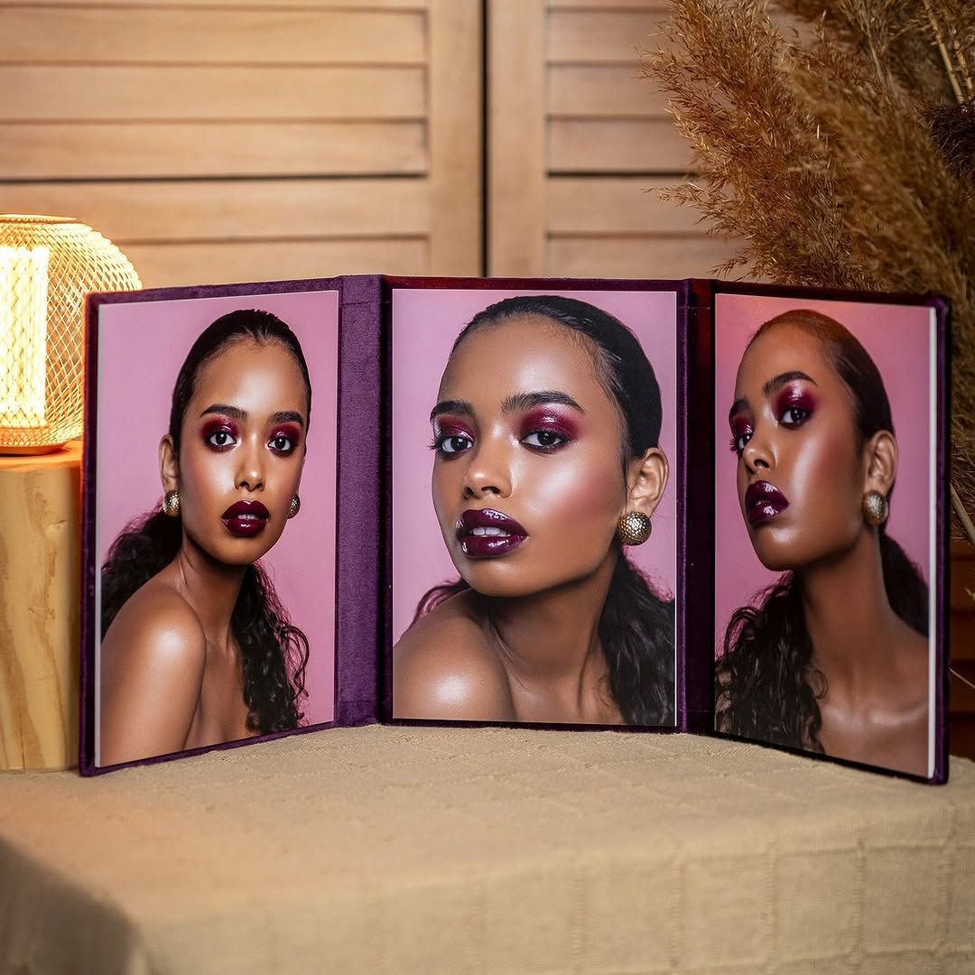 Three pictures of a woman's face are displayed on a table