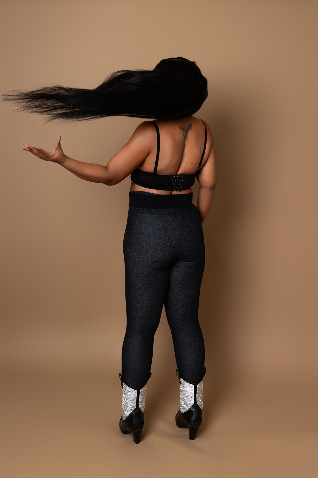 A woman is standing with her hair blowing in the wind.