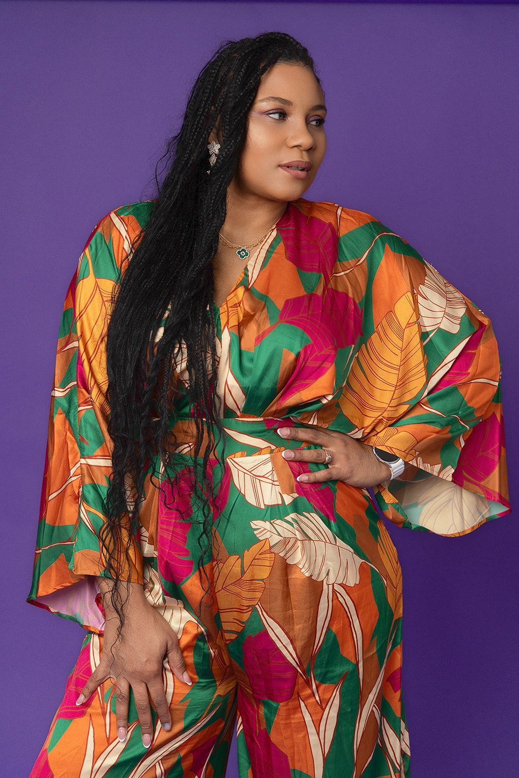 A woman with long hair is wearing a colorful jumpsuit