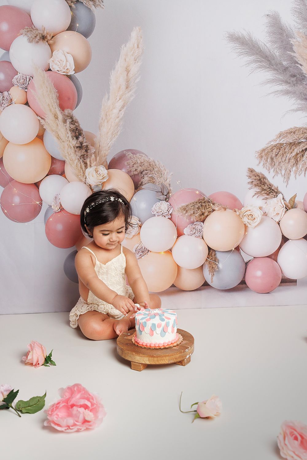 A little girl is sitting on the floor eating a cake