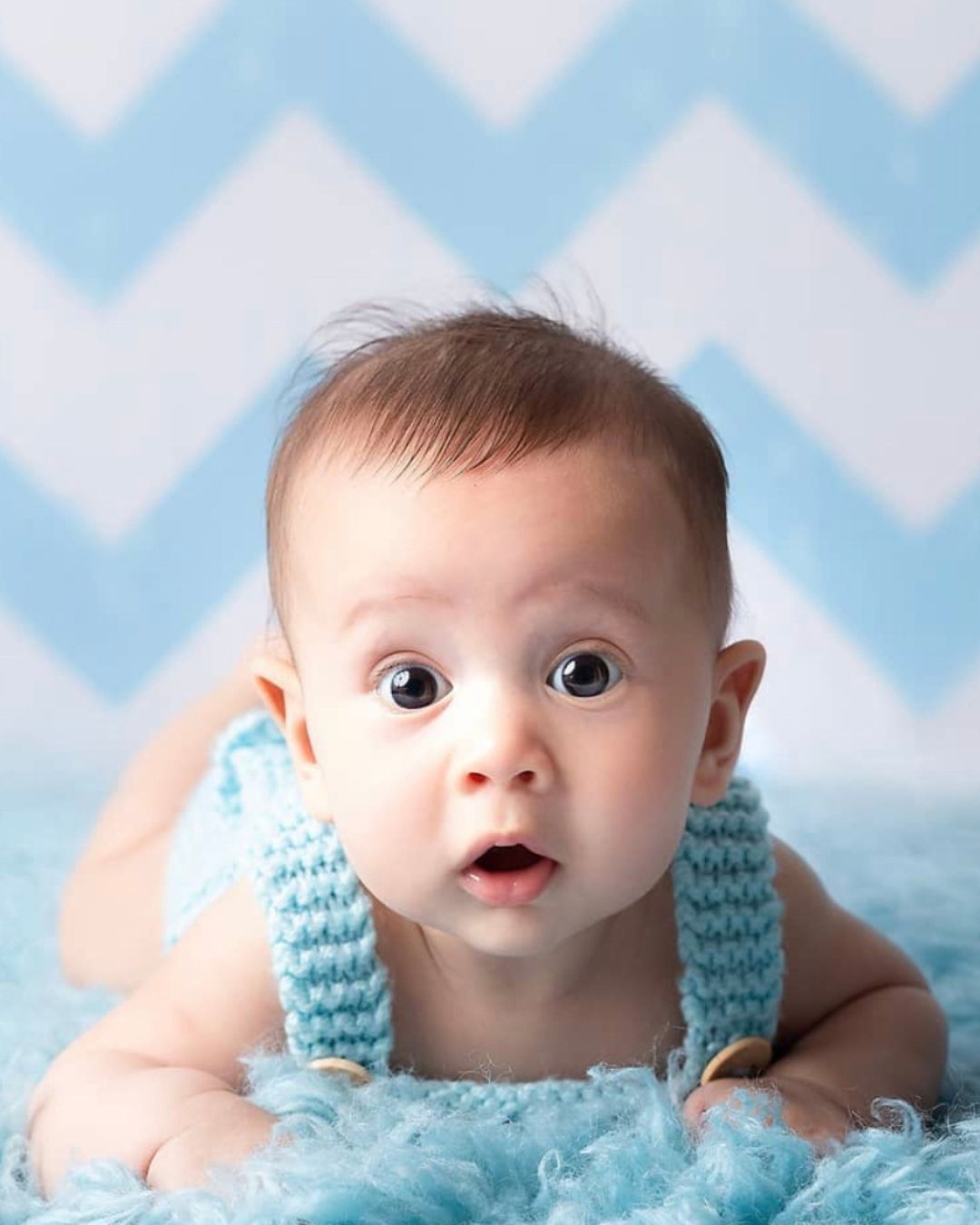 A baby is laying on his stomach