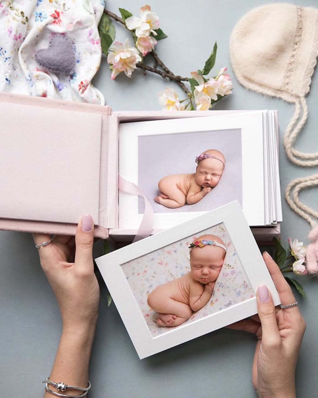 A person is holding a picture of a baby in a frame