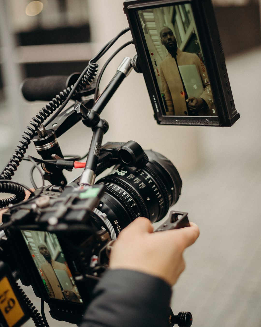 A person is holding a camera with a monitor attached to it