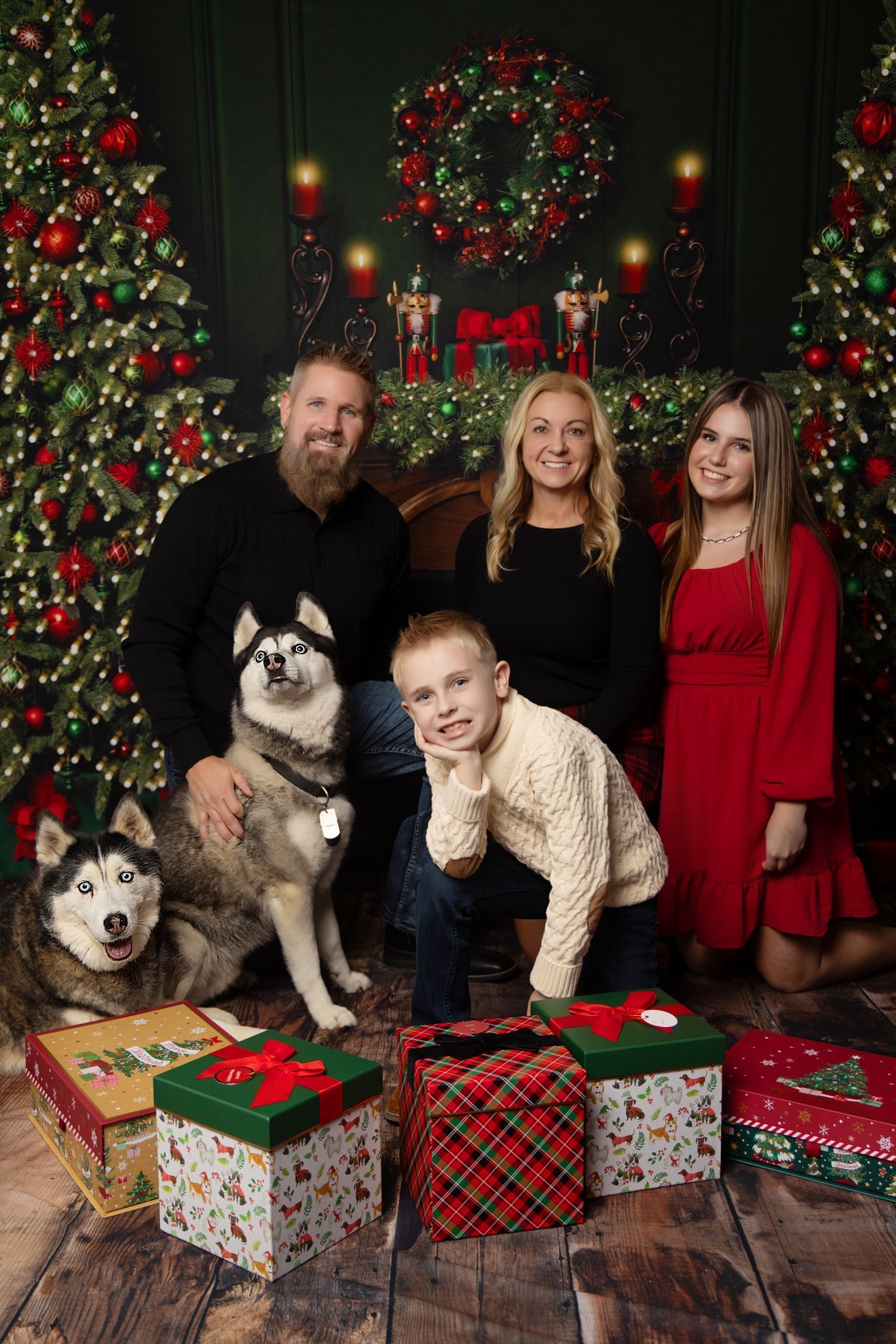 A family is posing for a picture in front of a christmas tree.