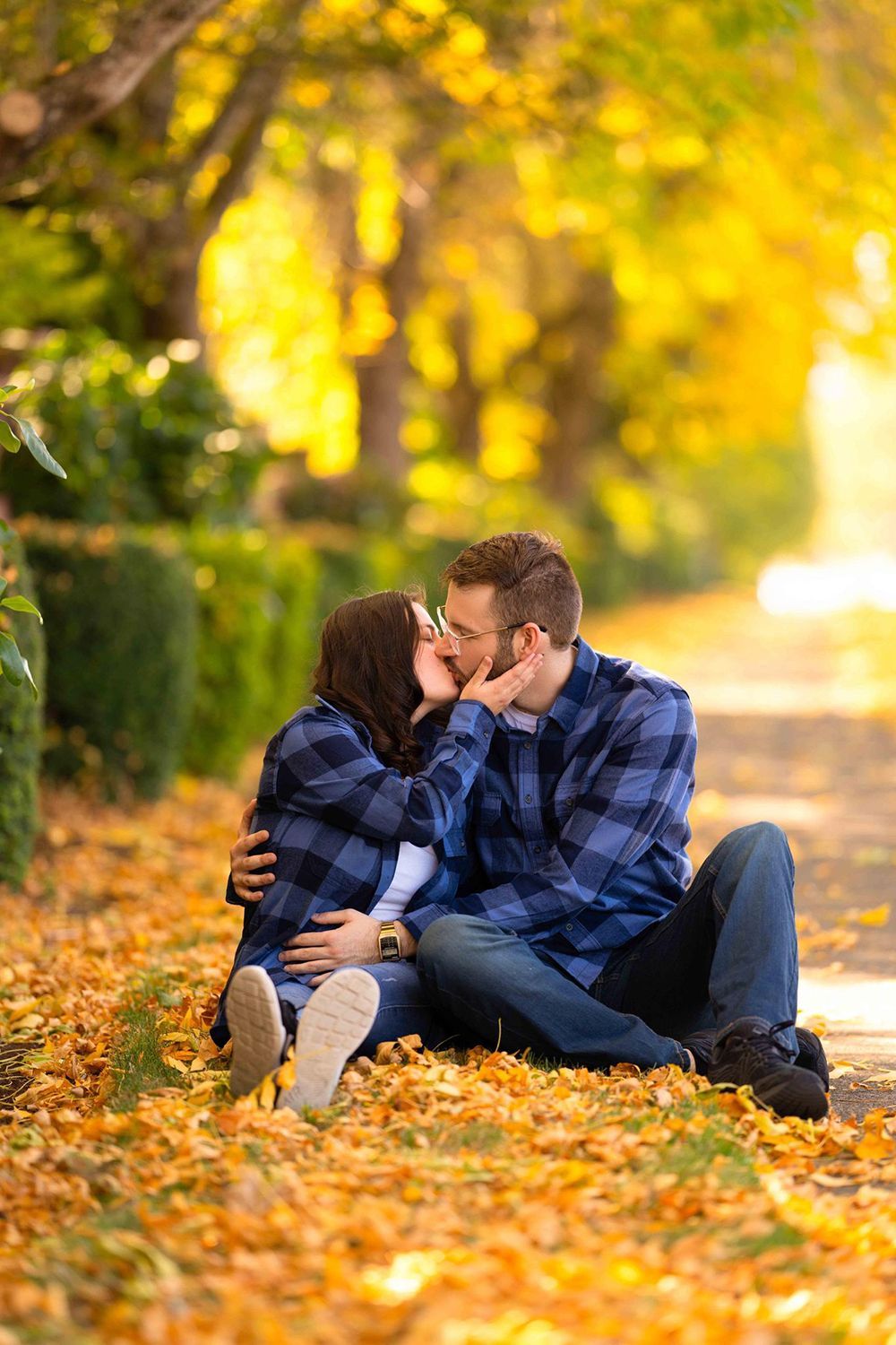 A man and a woman are sitting on the ground kissing