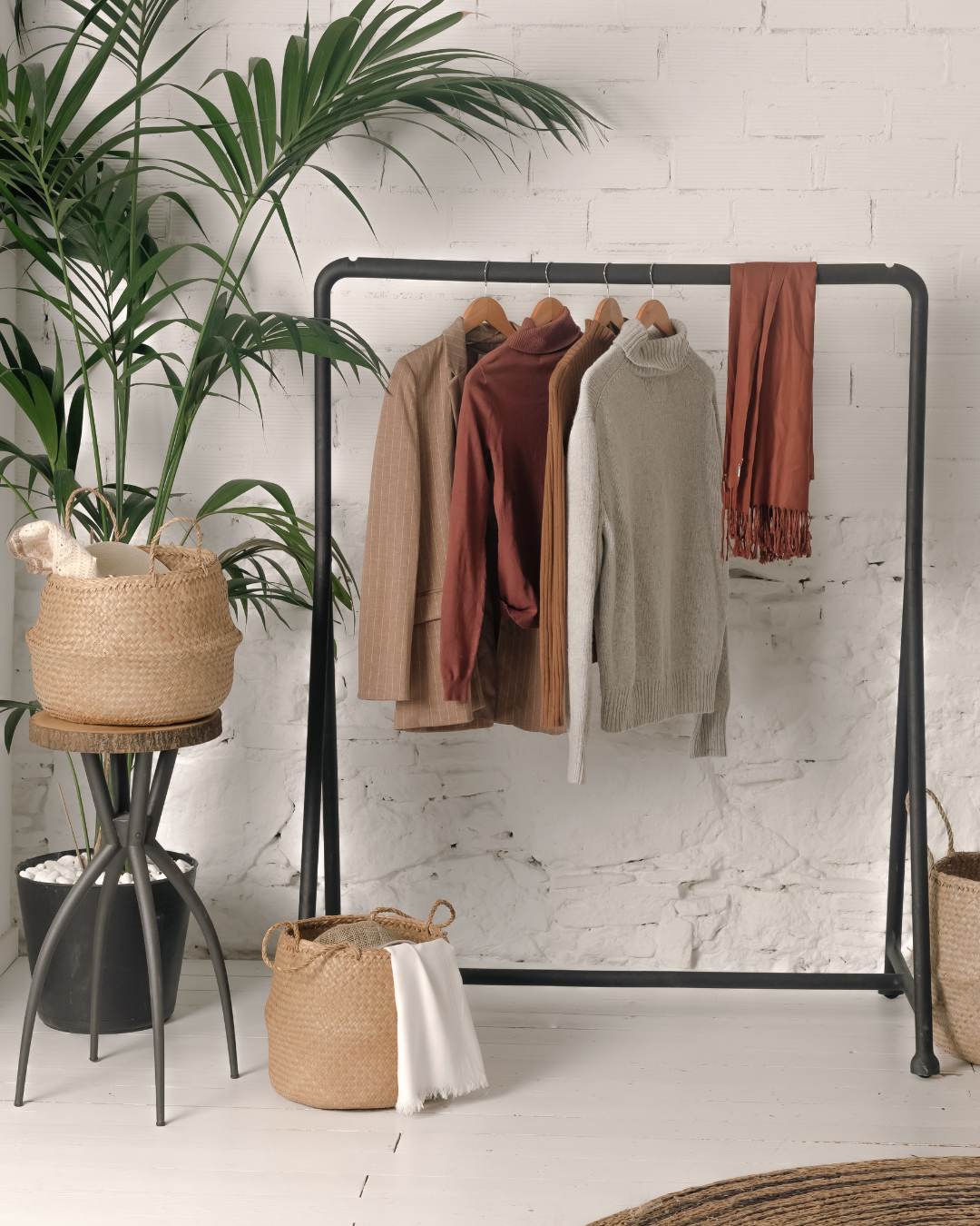 A clothes rack with clothes hanging on it in a room.