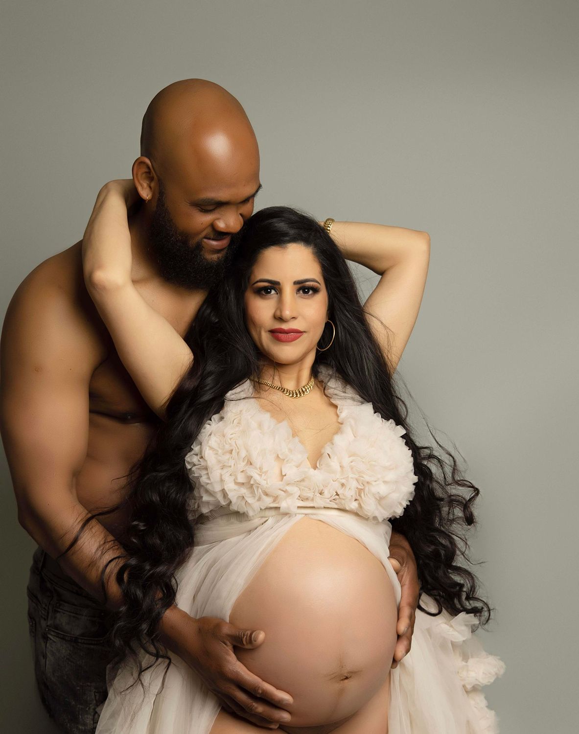 A man is hugging a pregnant woman