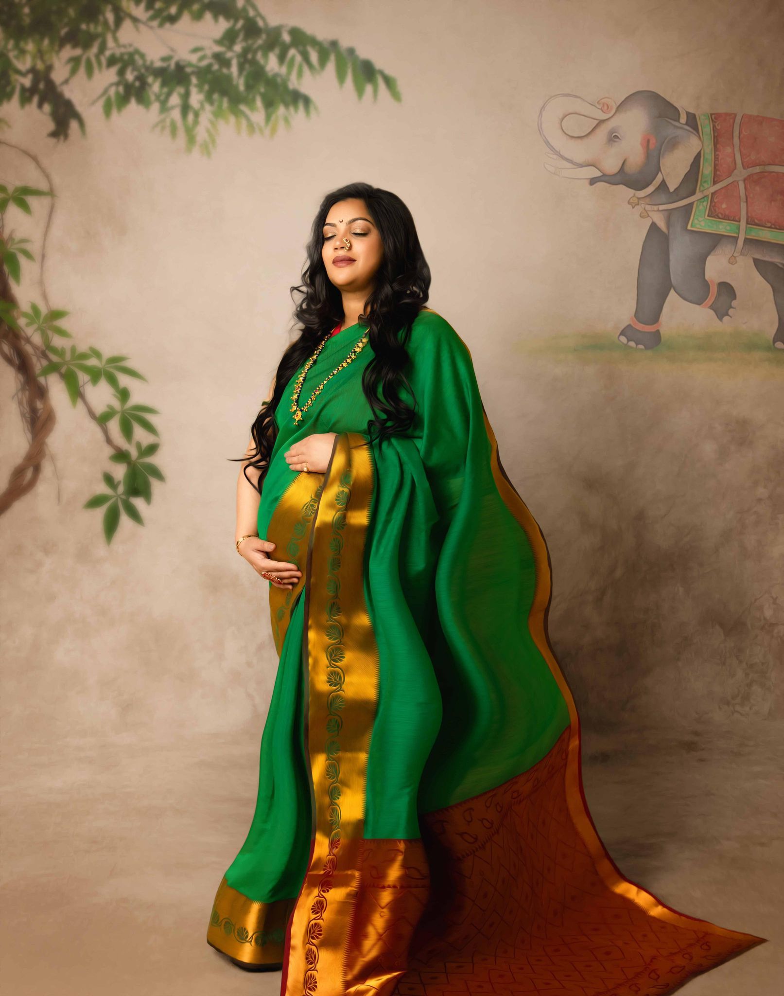 A pregnant woman is wearing a green and gold saree