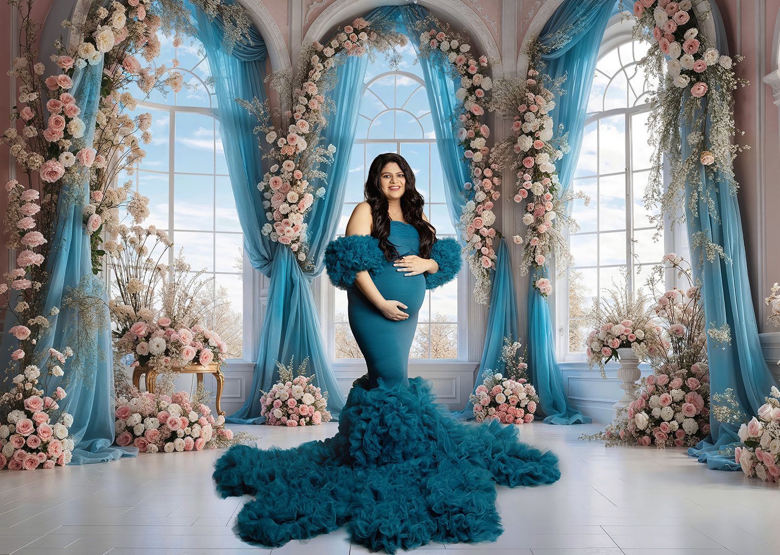 A pregnant woman in a blue dress is standing in front of a window surrounded by flowers.
