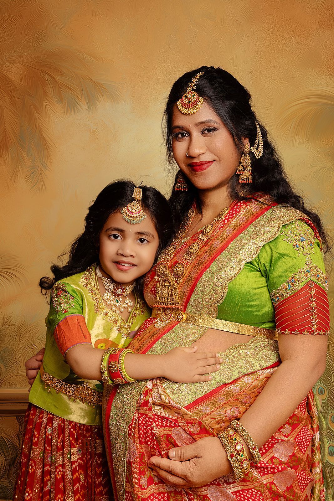 A pregnant woman and a little girl are posing for a picture.