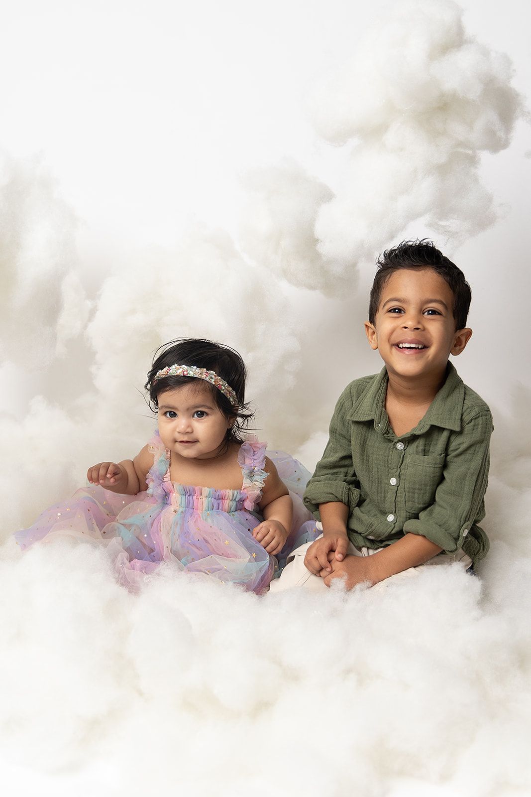 A boy and a girl are sitting on a cloud