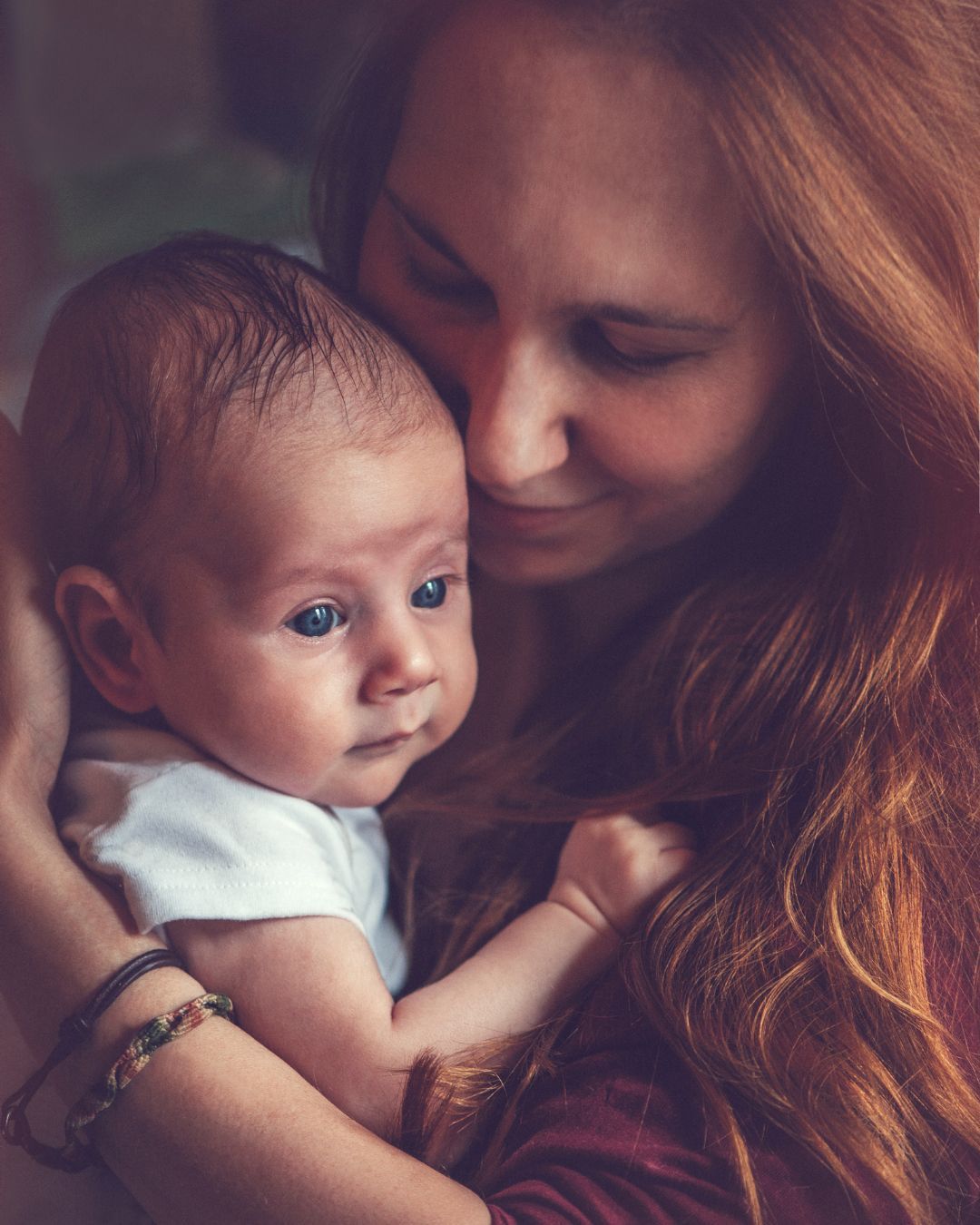 A woman is holding a baby in her arms