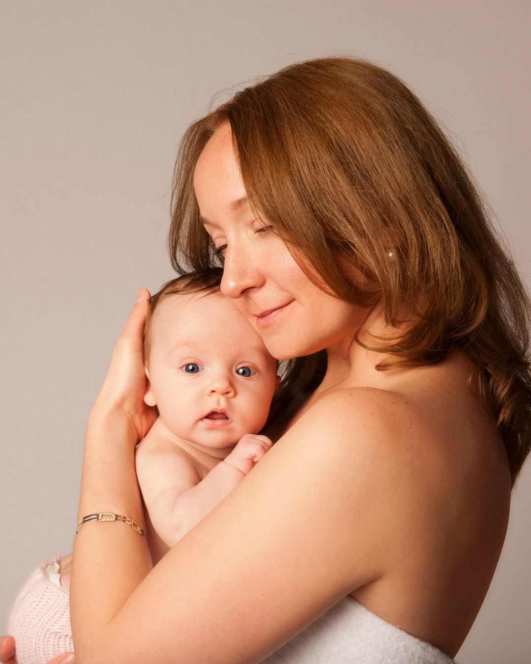 A woman is hugging her baby