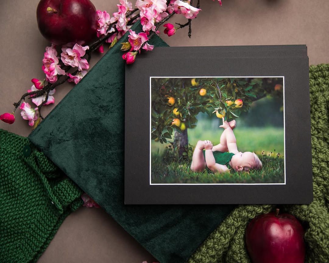 A picture of a baby laying in the grass