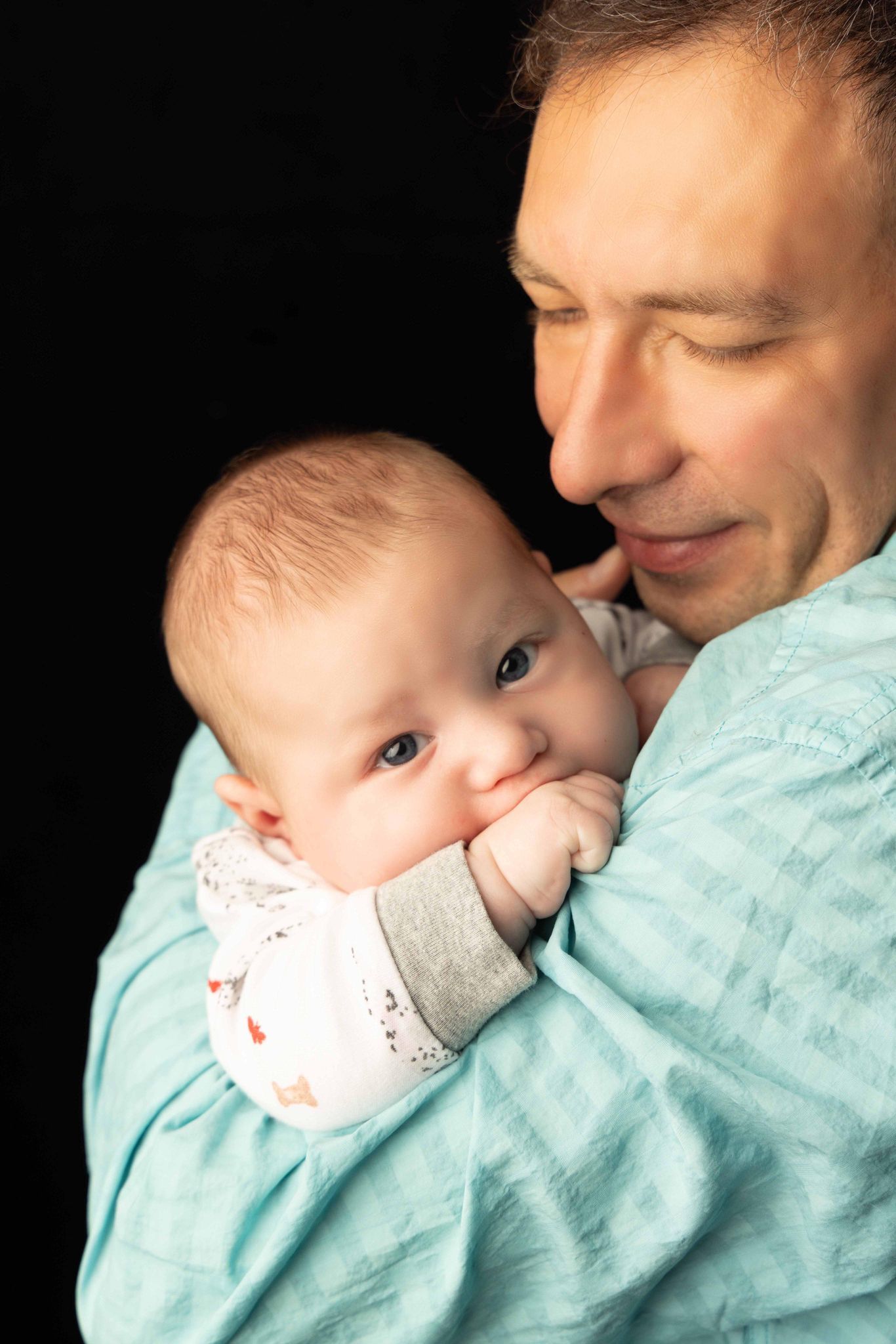 A man is holding a baby in his arms.