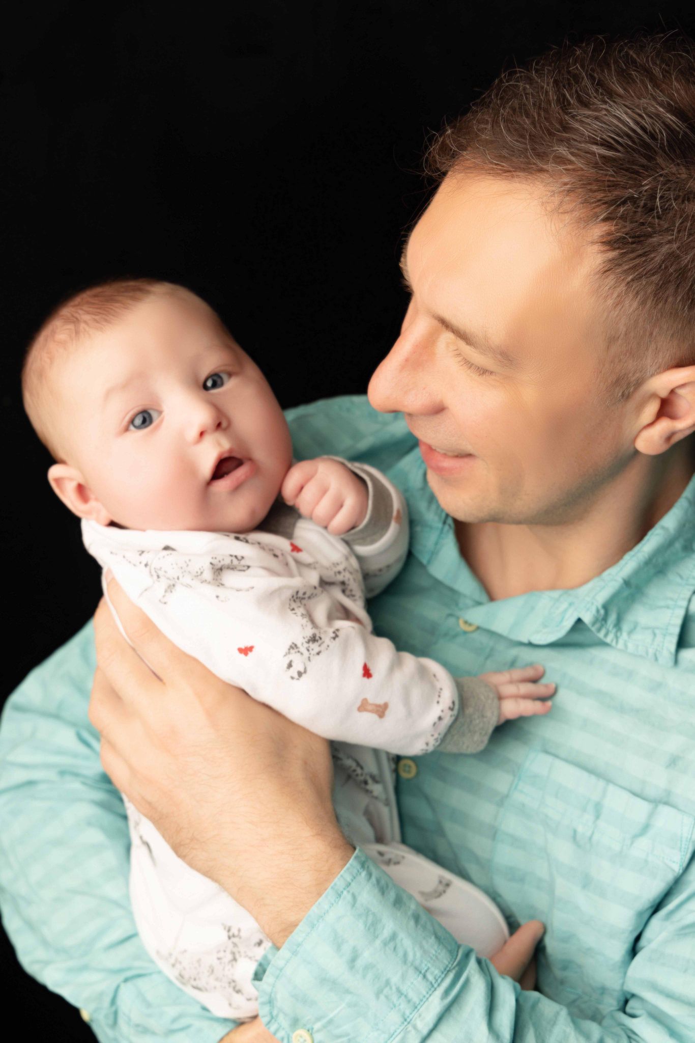 A man is holding a baby in his arms.