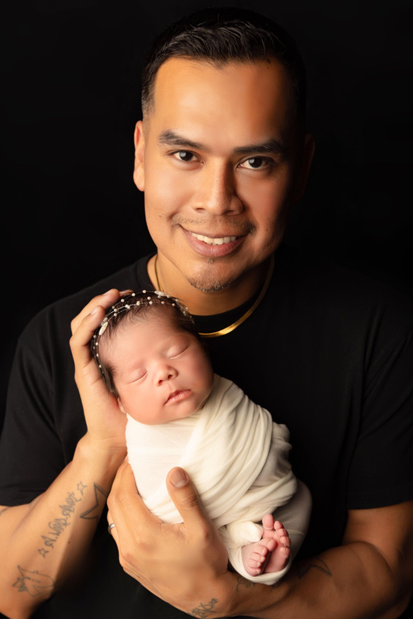 A man is holding a newborn baby in his arms.
