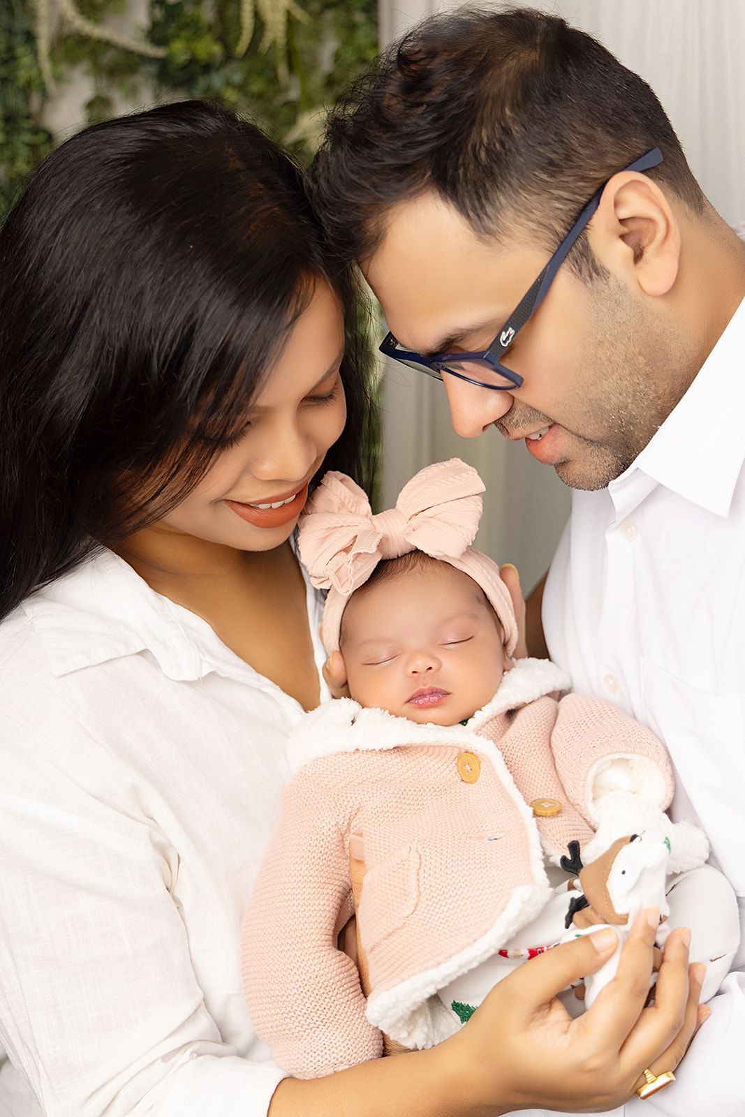 A man and woman are holding a newborn baby in their arms.