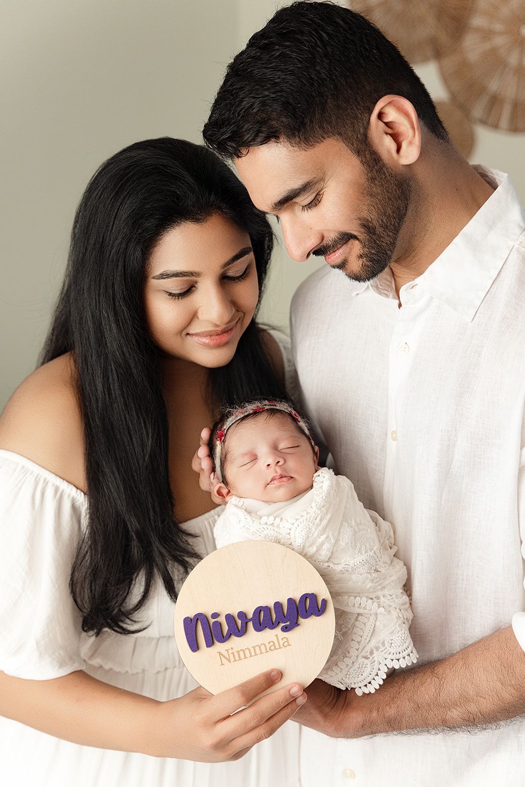 A man and a woman are holding a newborn baby.