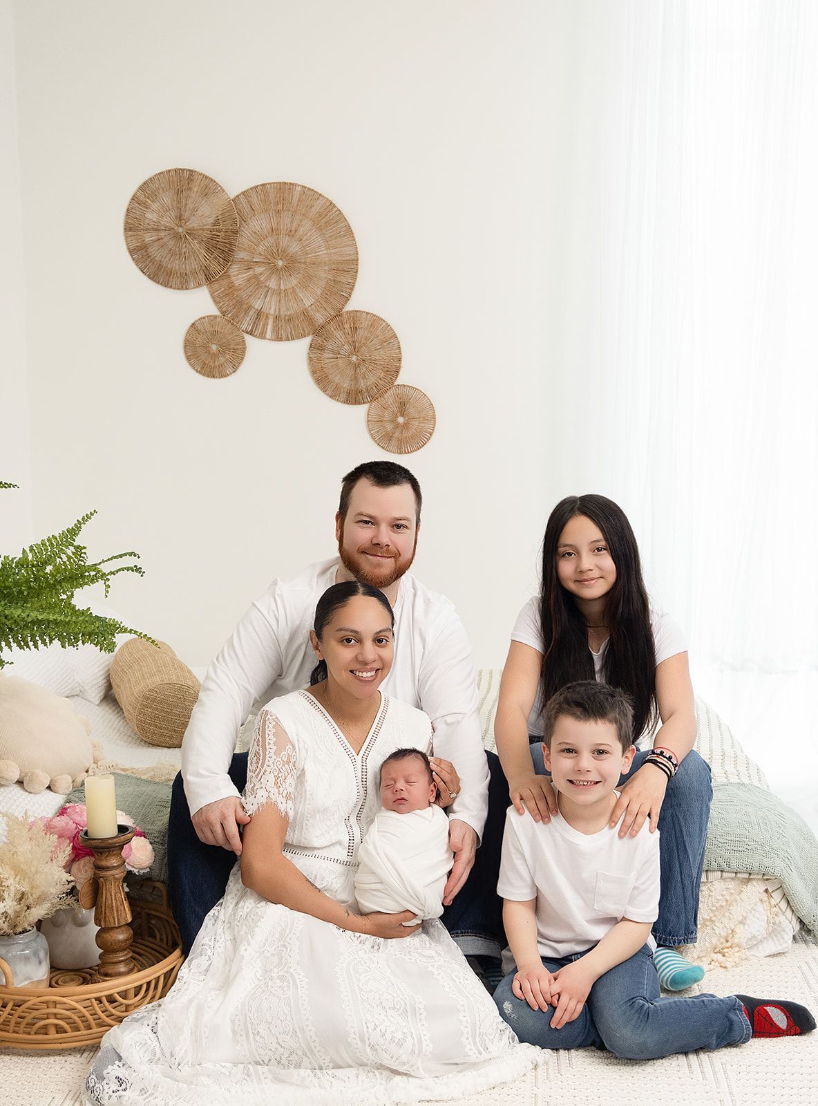 A family is posing for a picture with a newborn baby.