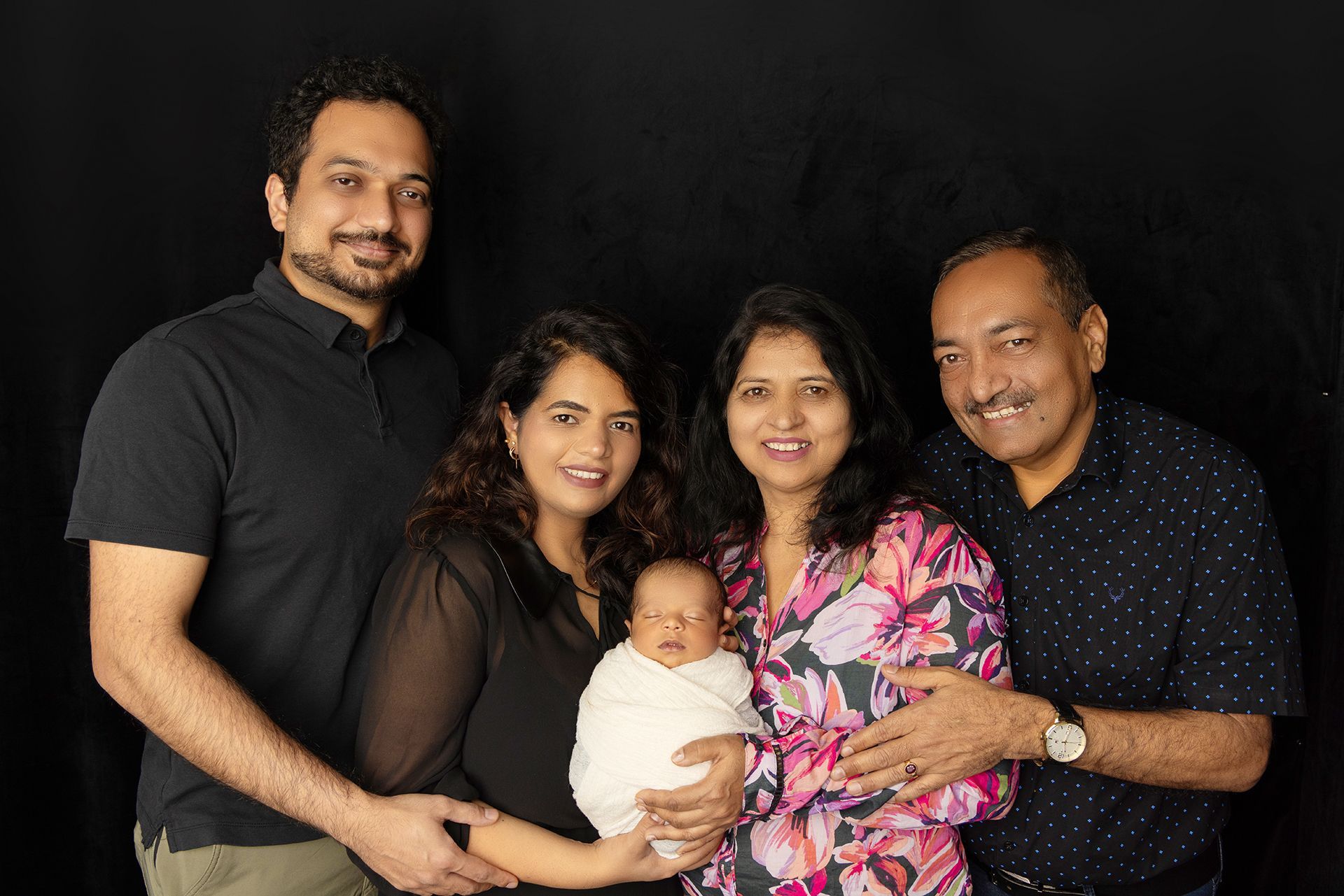 Newborn baby with parents and grandparents