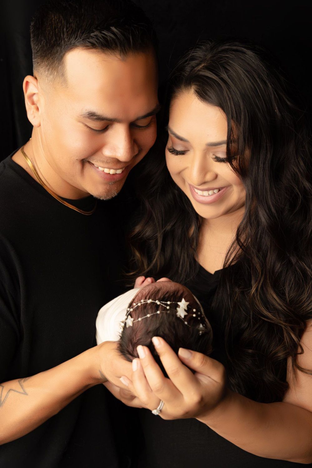 A man and a woman are holding a newborn baby in their arms