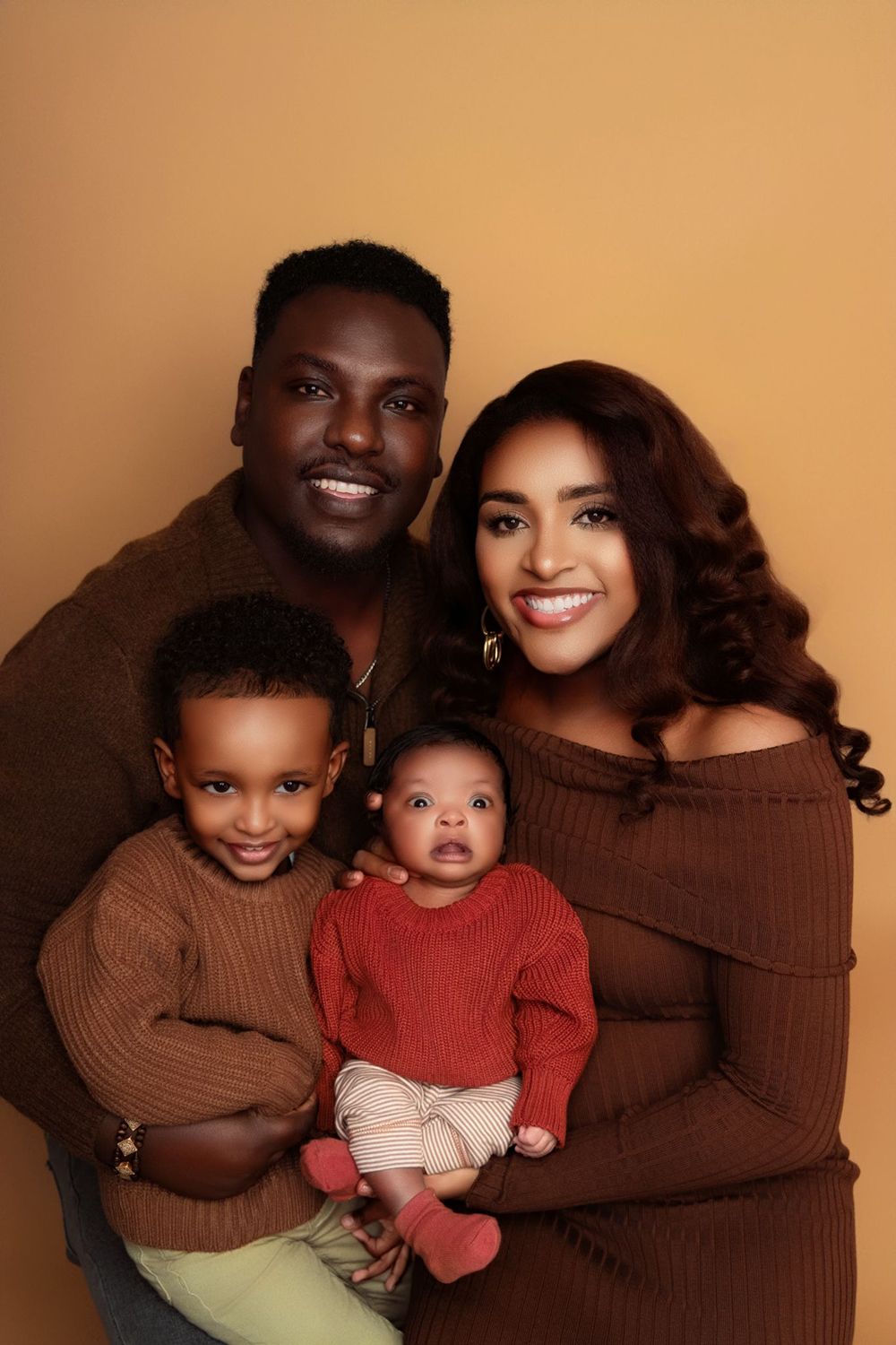 A family is posing for a picture together and smiling for the camera